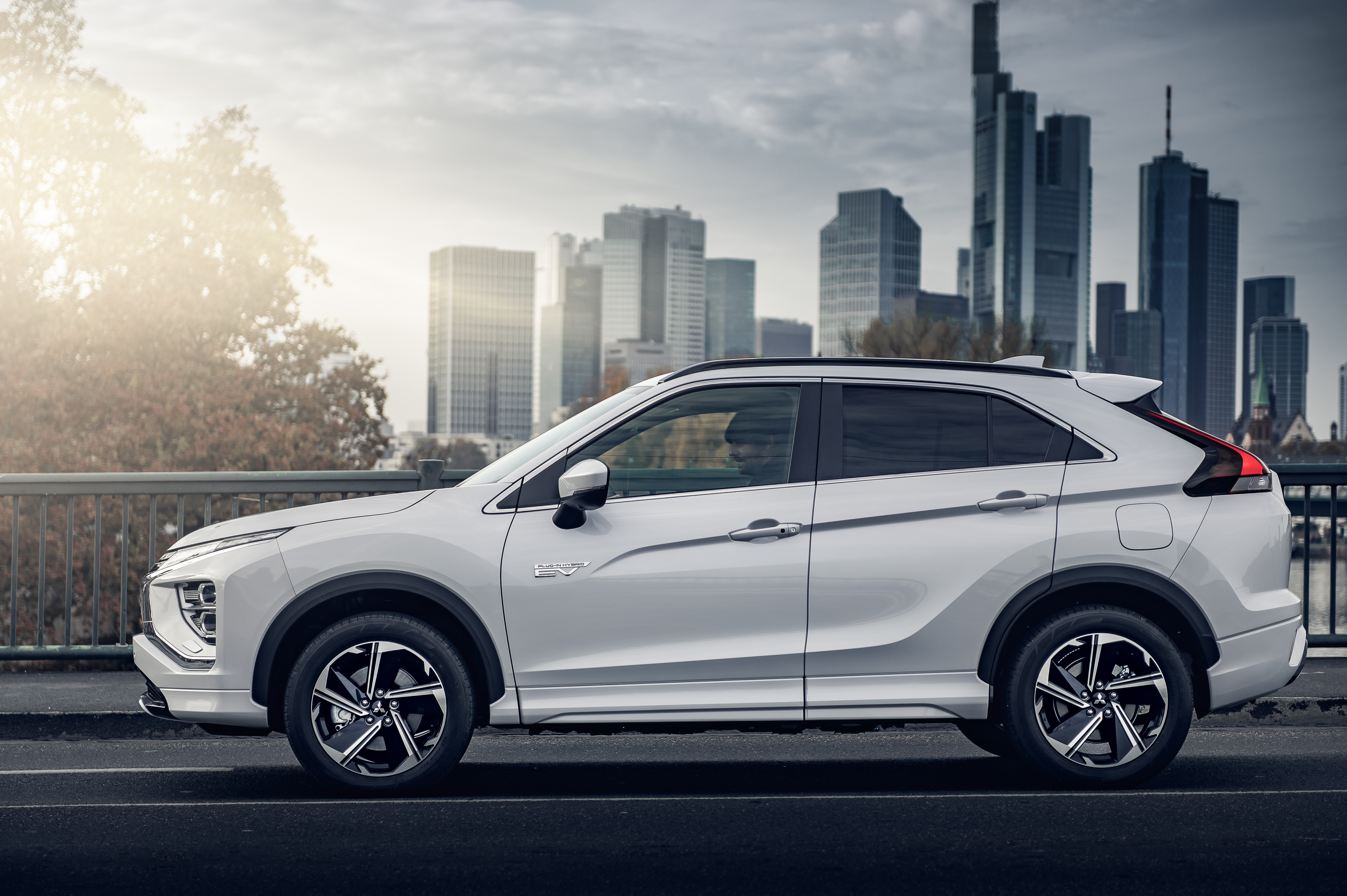 White Mitsubishi Eclipse Cross SUV against city backdrop HD Wallpaper