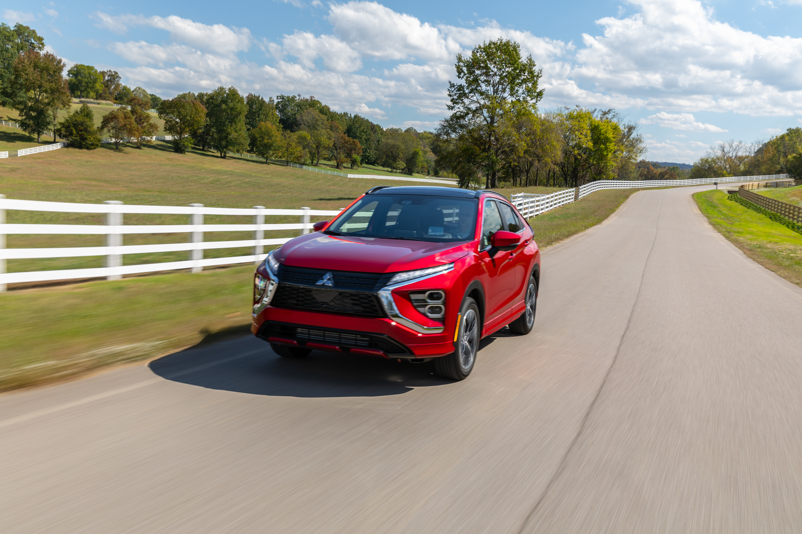 Red Mitsubishi Eclipse Cross SUV on a country road HD Wallpaper