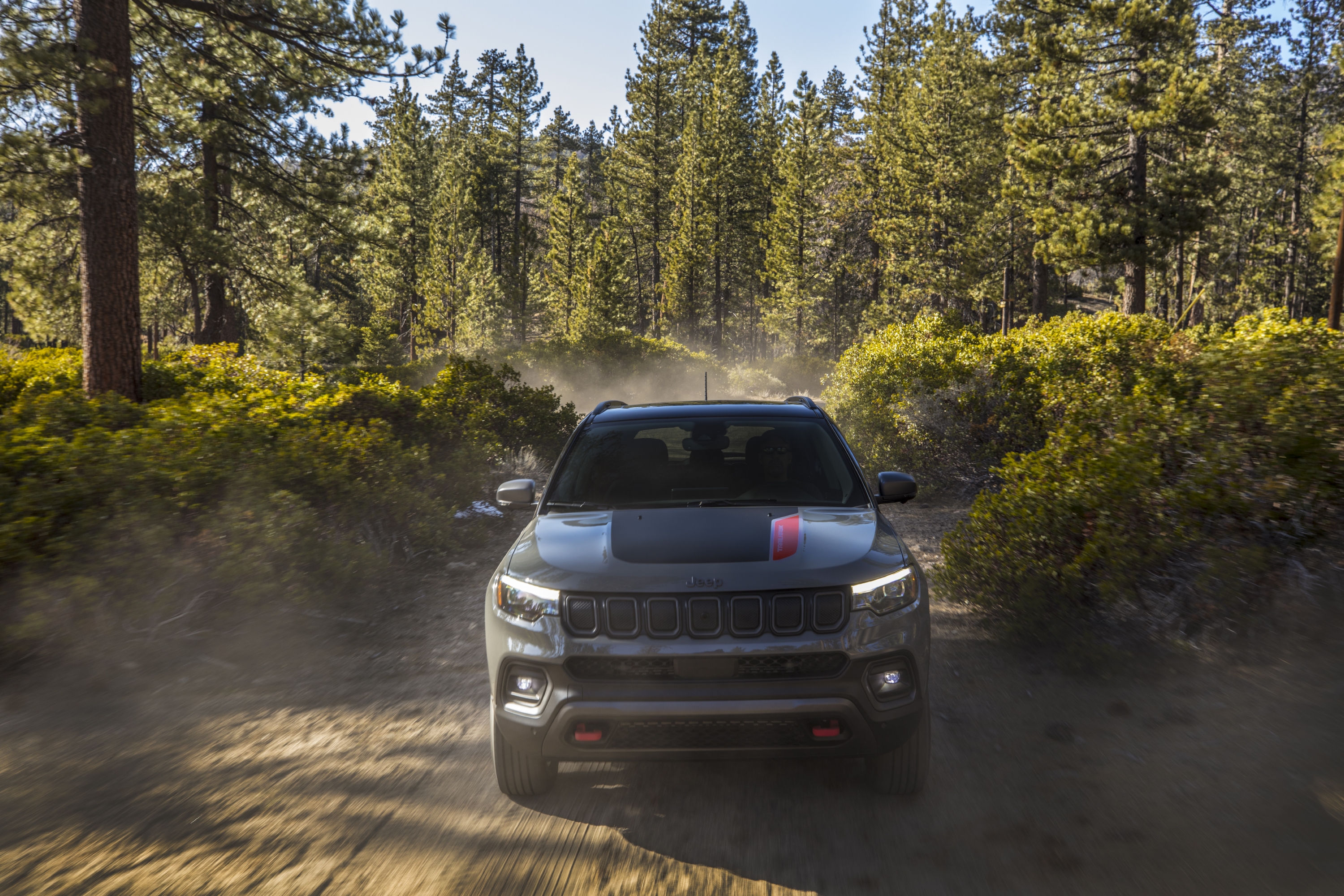 2022 Jeep Compass Trailhawk SUV driving on a dusty forest trail HD Wallpaper