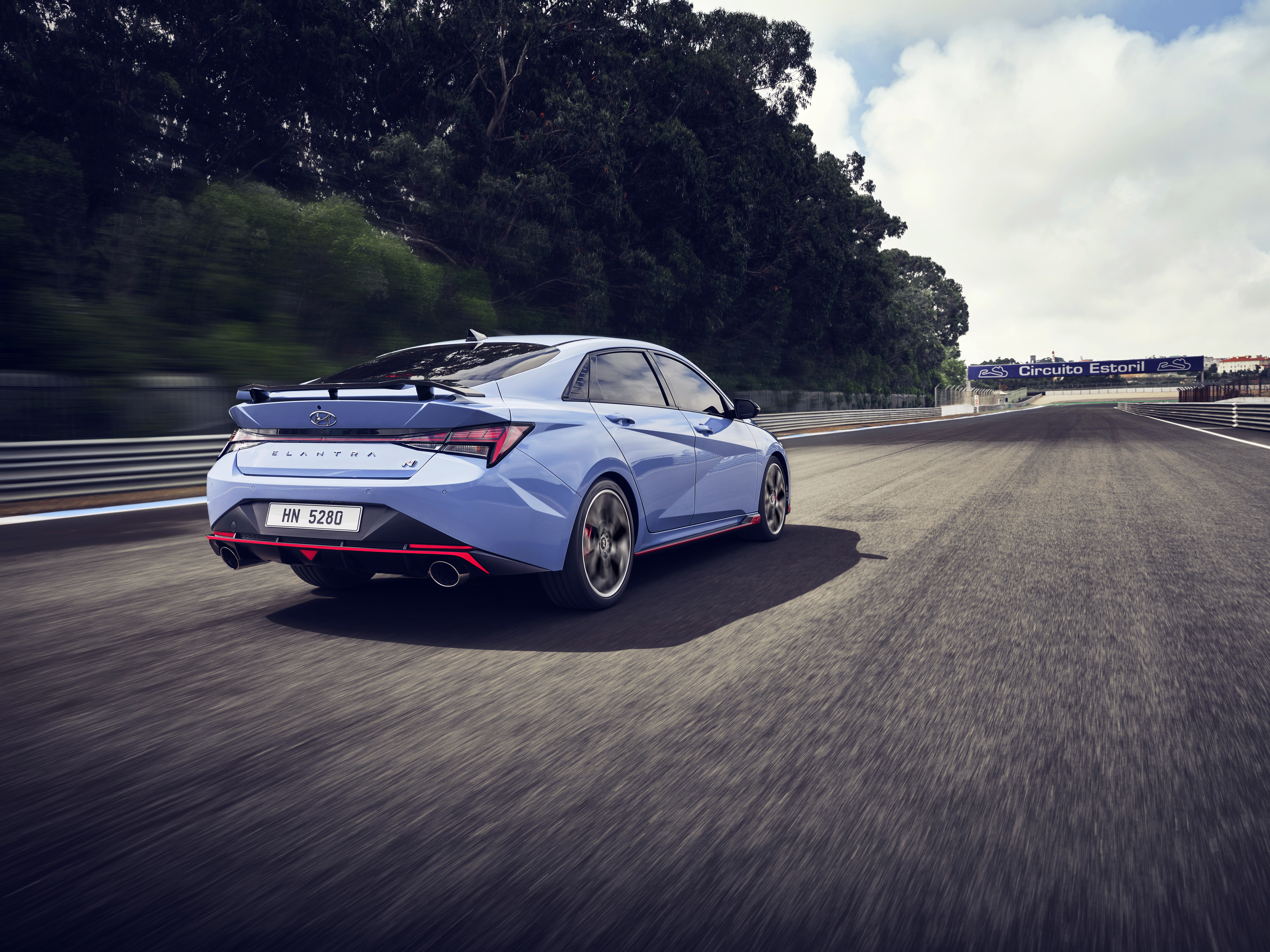 Blue Hyundai Elantra N speeding on Circuito Estoril race track HD Wallpaper