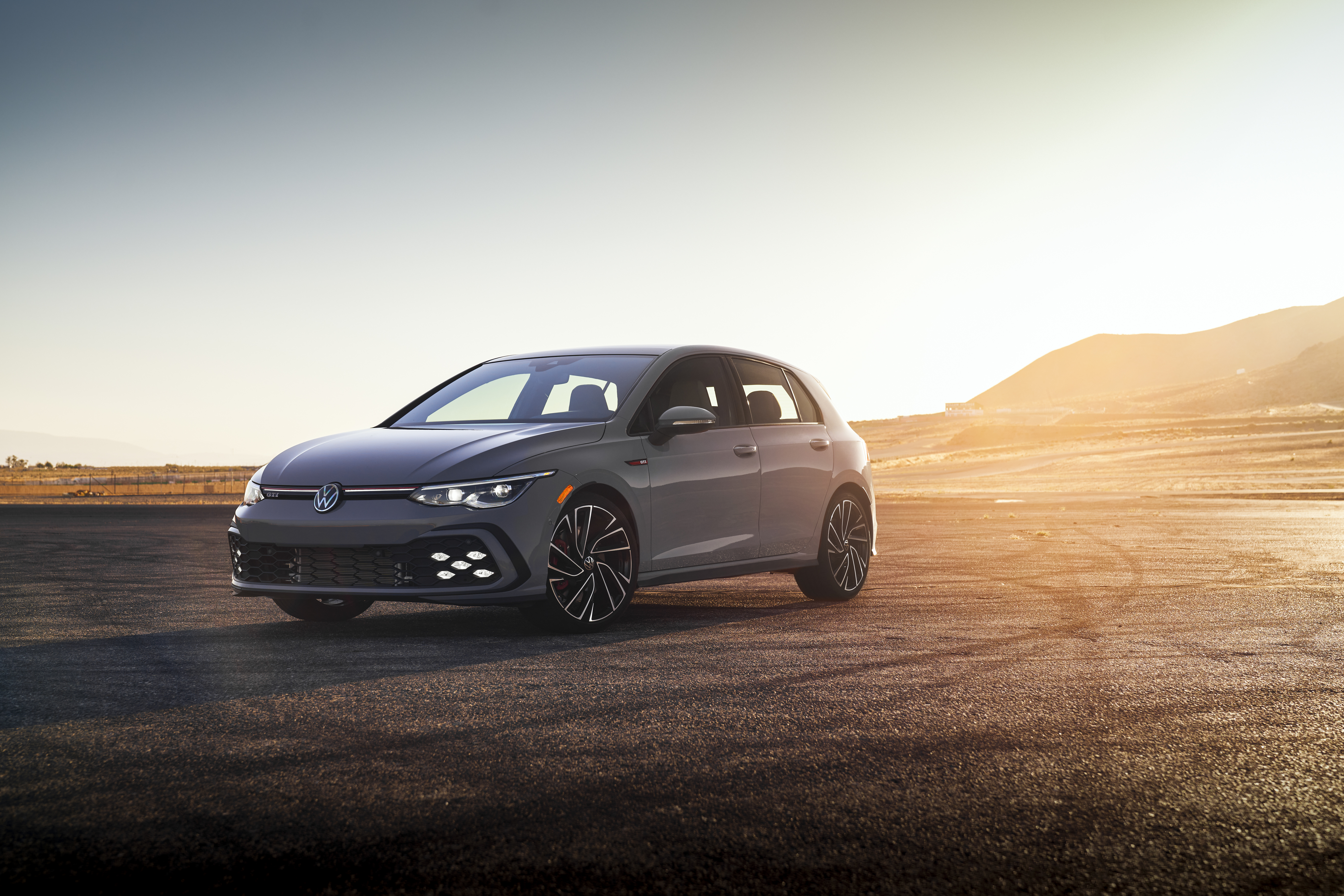 2022 Volkswagen Golf GTI in a sunlit desert landscape HD Wallpaper