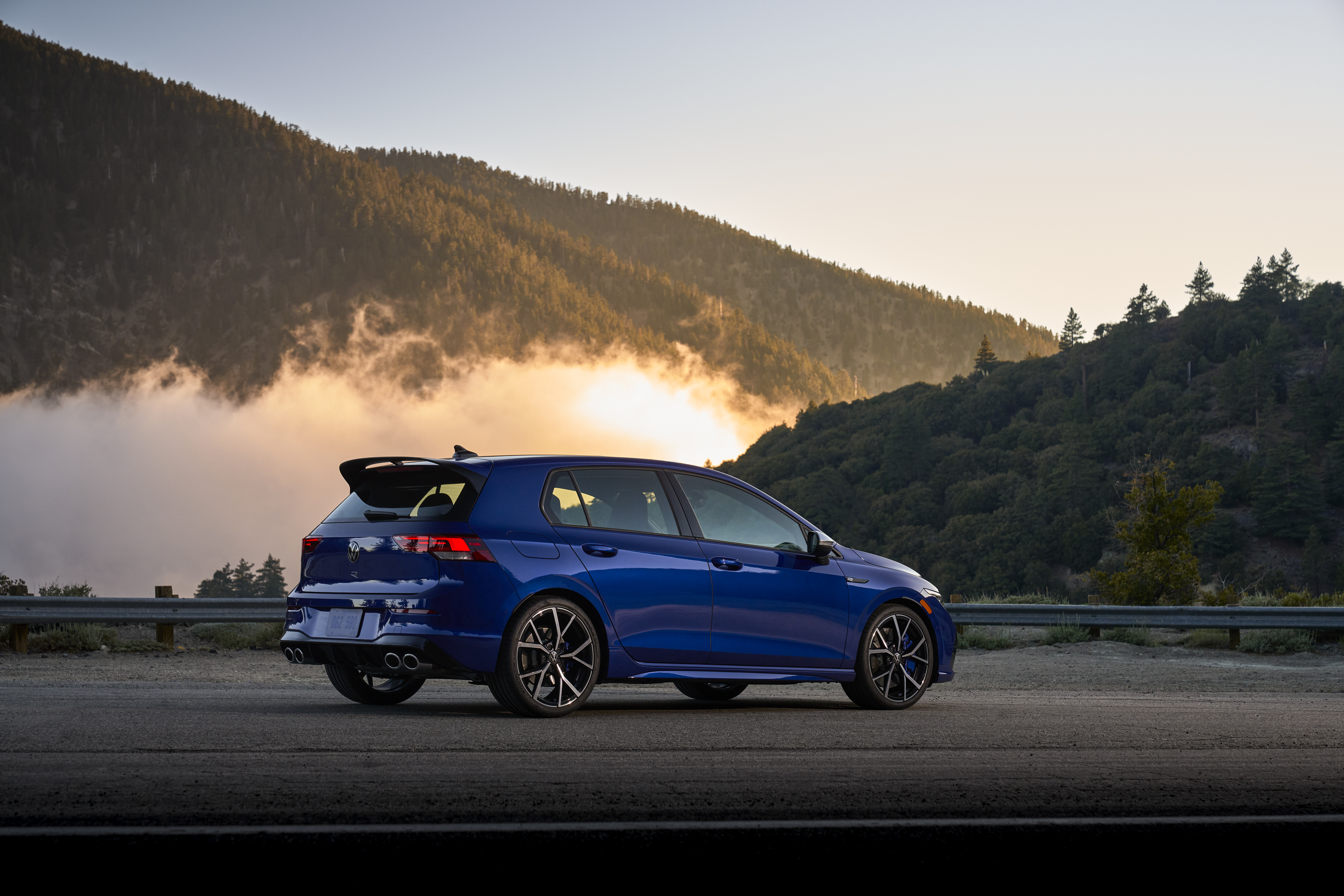 Blue Volkswagen Golf R on a mountain road at sunset HD Wallpaper