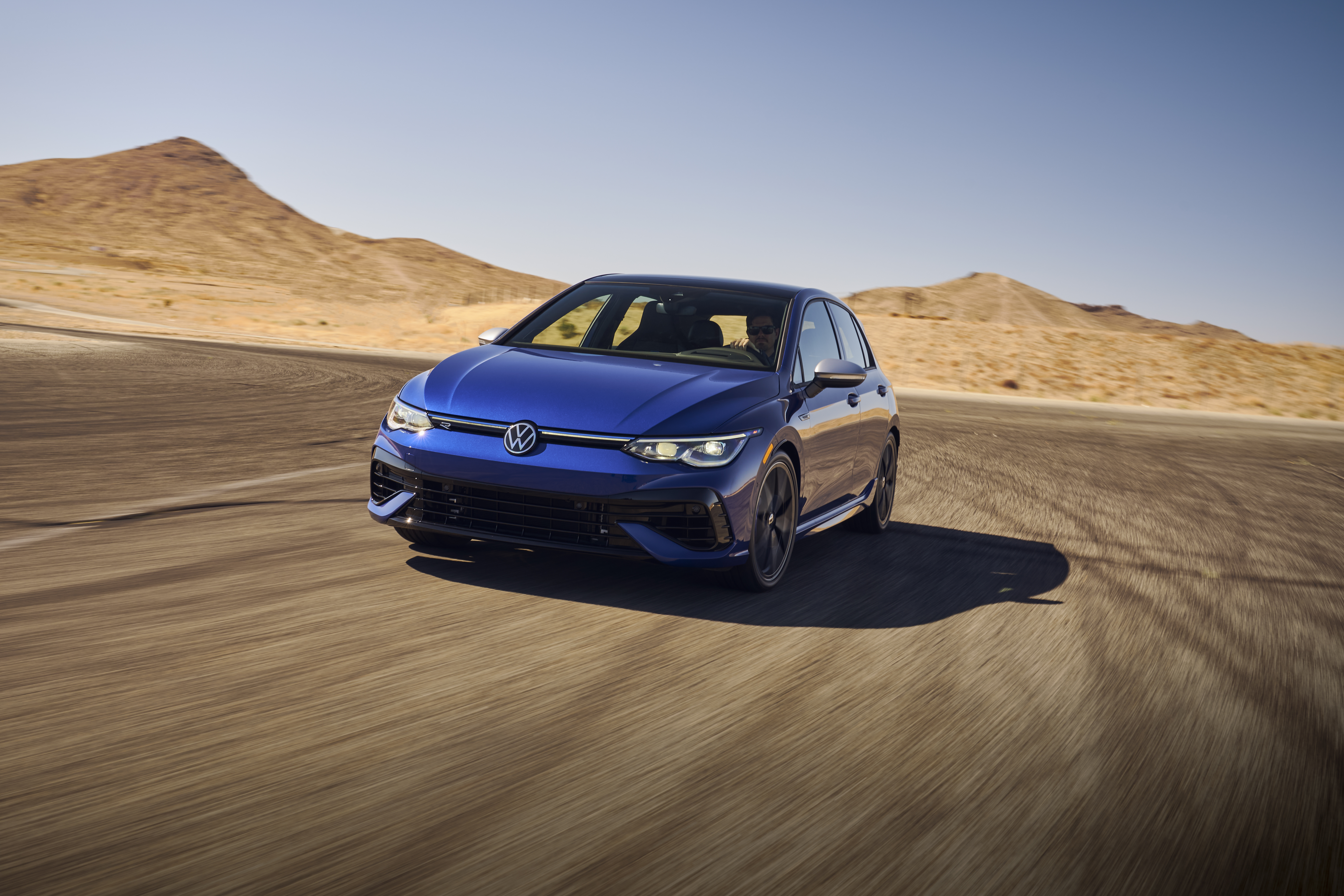 Blue 2022 Volkswagen Golf R on a desert road HD Wallpaper
