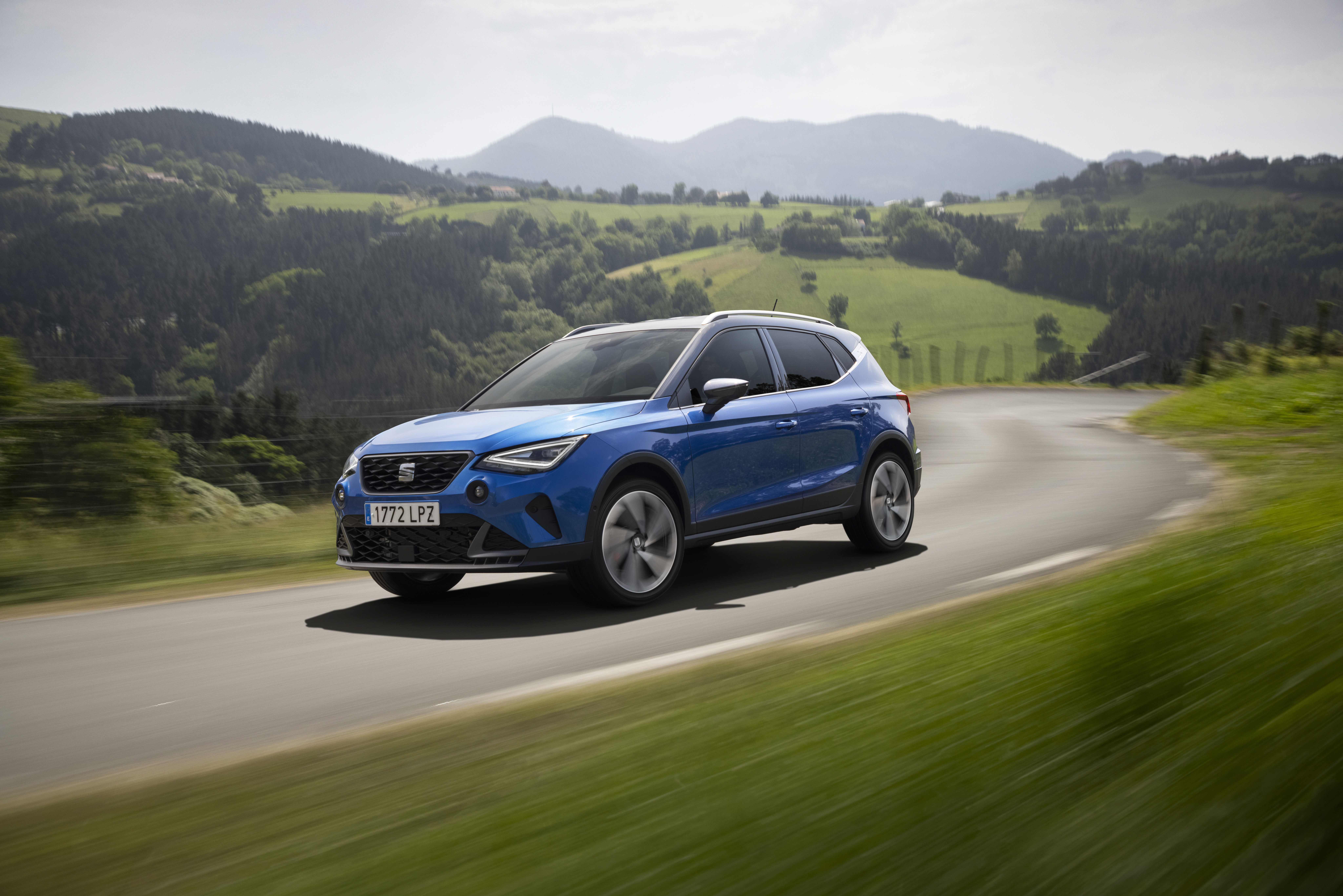 Blue 2021 SEAT Arona FR driving on a scenic road HD Wallpaper