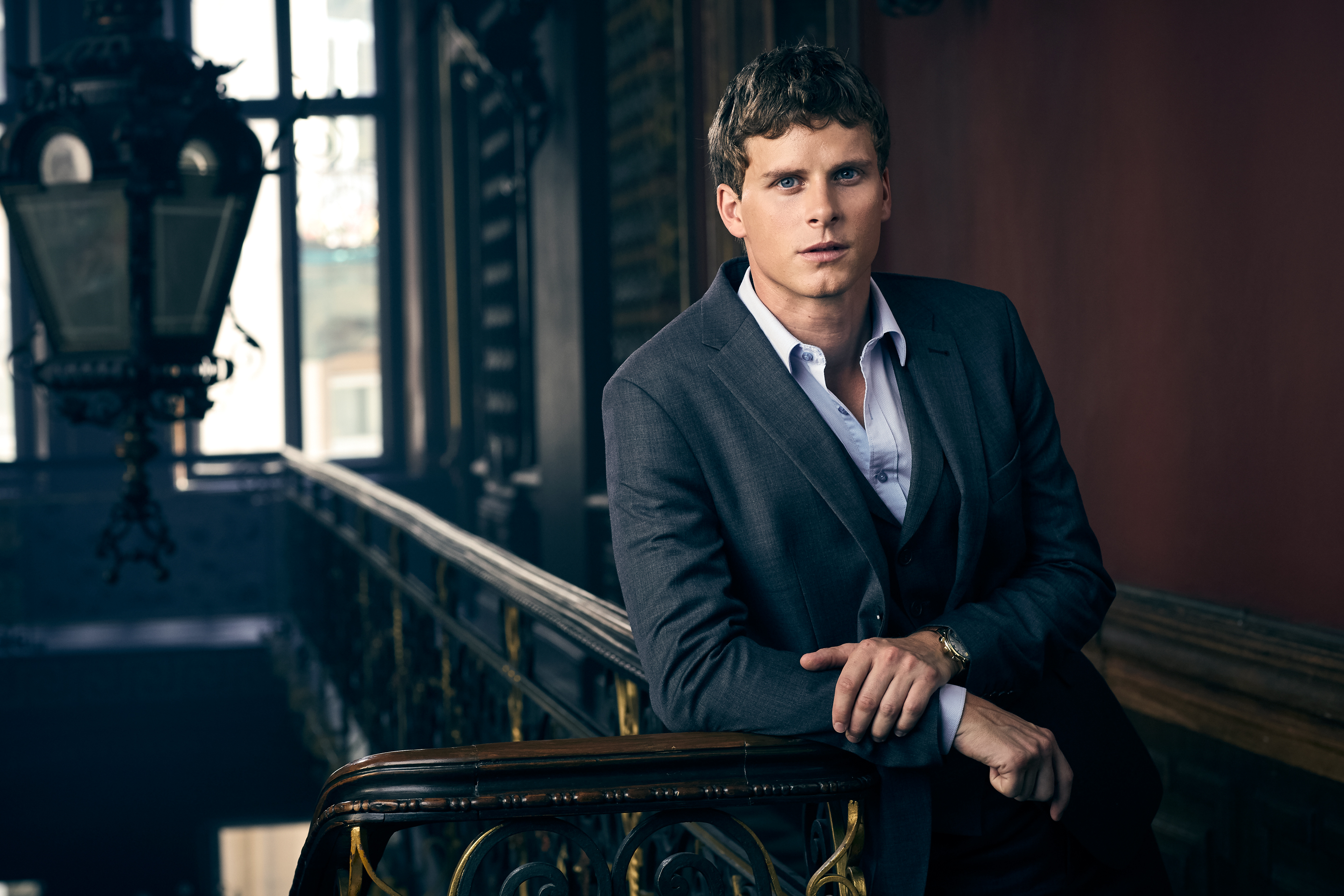 Adam Pålsson in a suit leaning on a railing HD Wallpaper