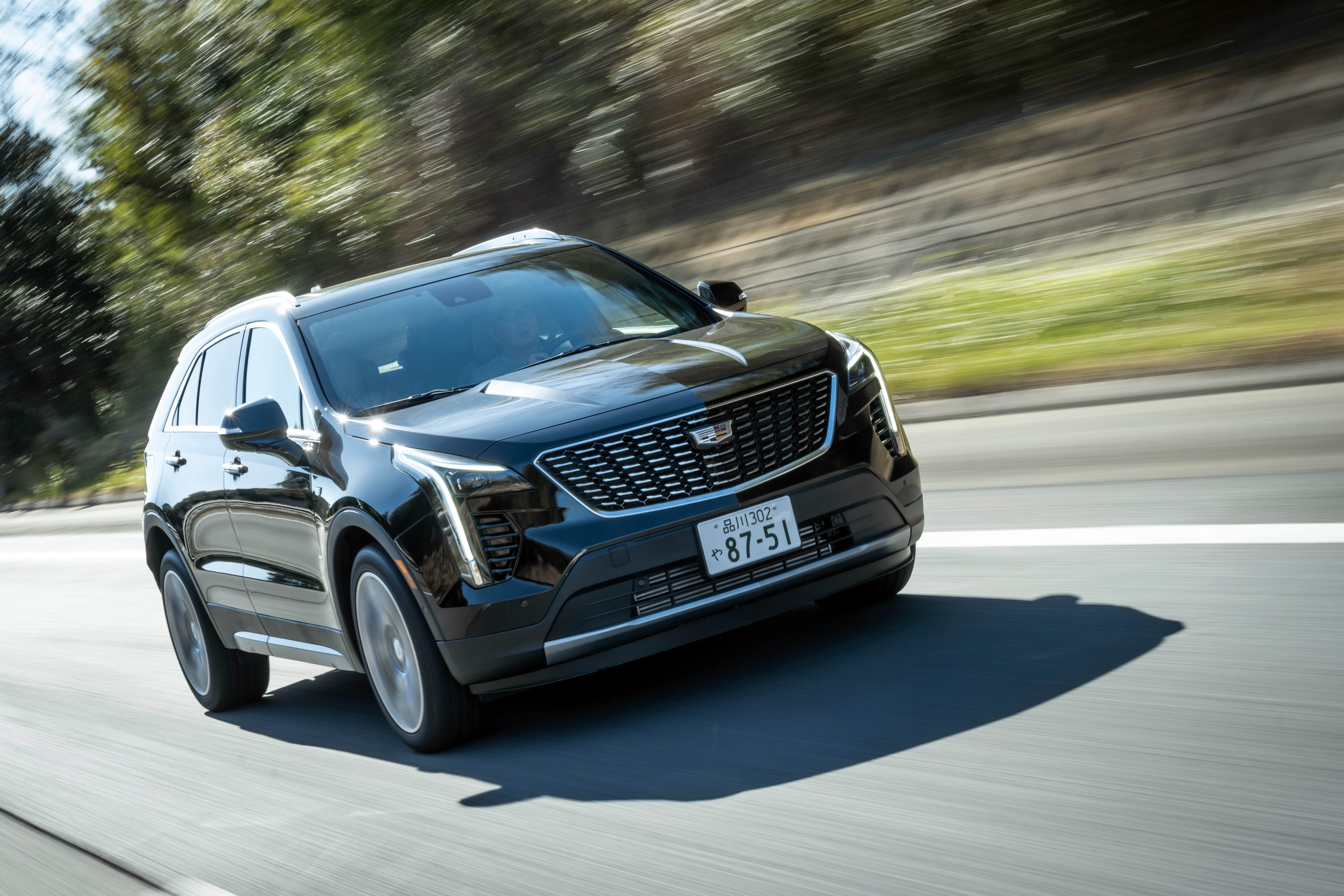 Black Cadillac XT4 350T Sport driving on a road HD Wallpaper
