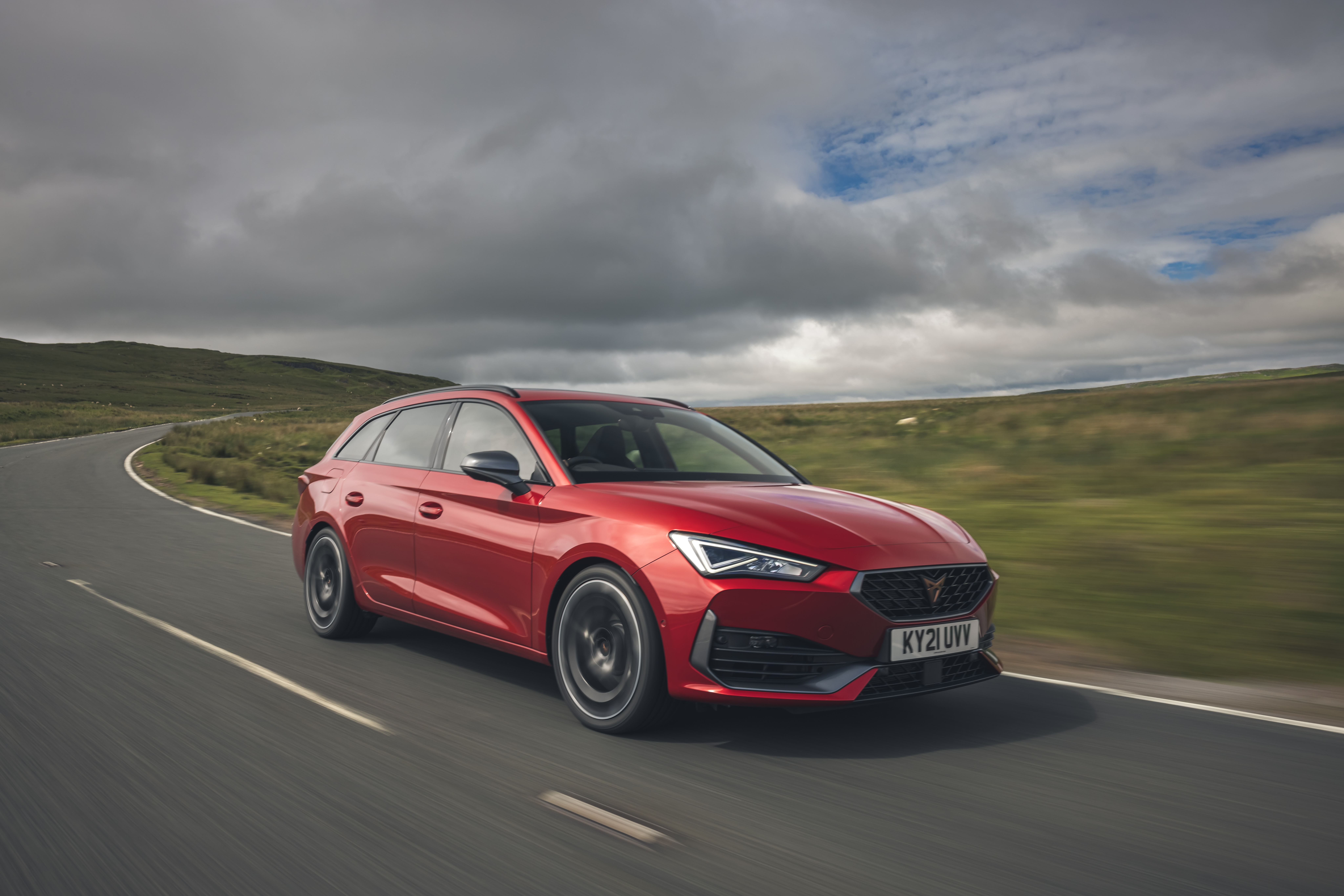 Red 2021 Cupra Leon Estate driving on a winding road HD Wallpaper