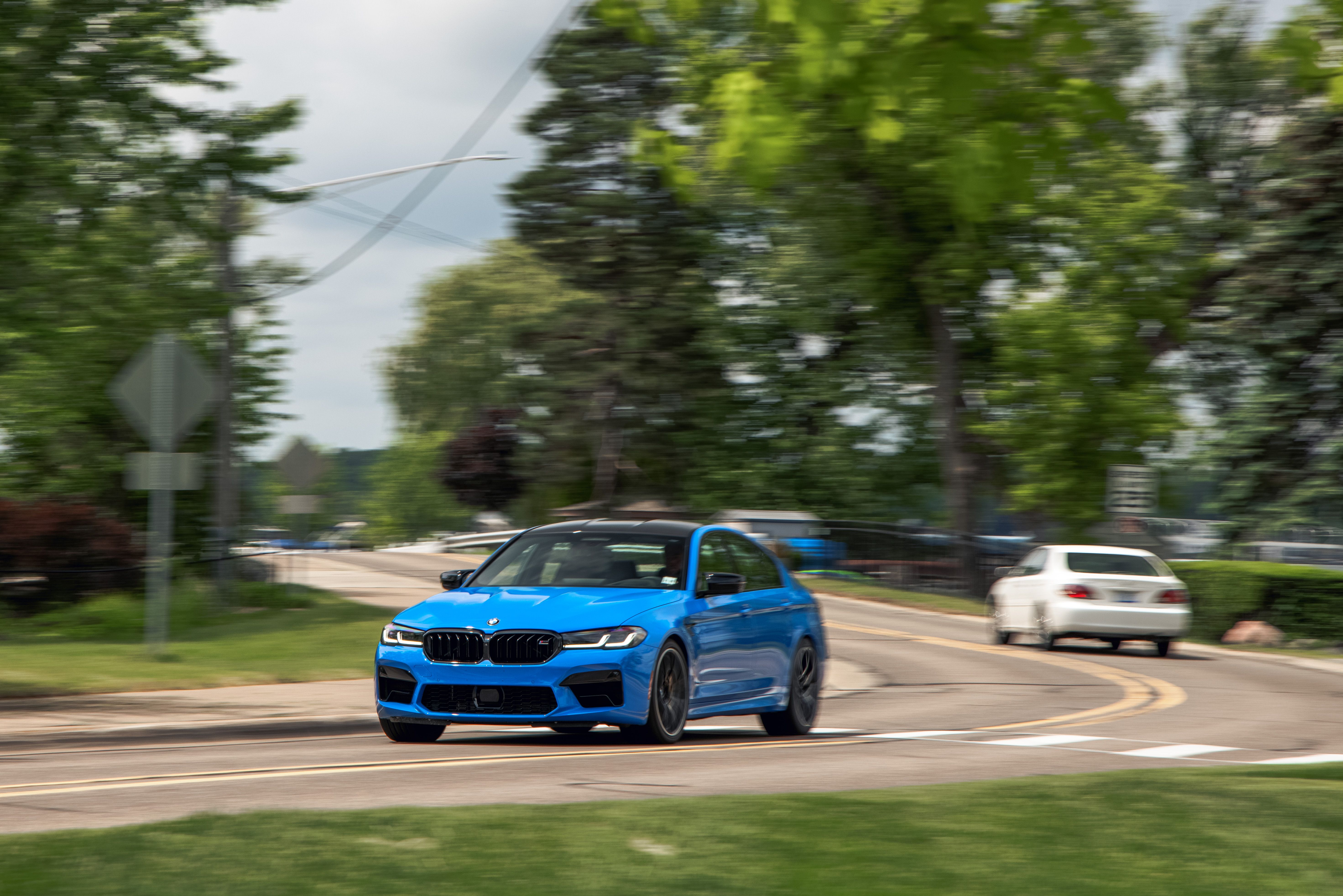 Blue 2021 BMW M5 Competition driving on a road HD Wallpaper