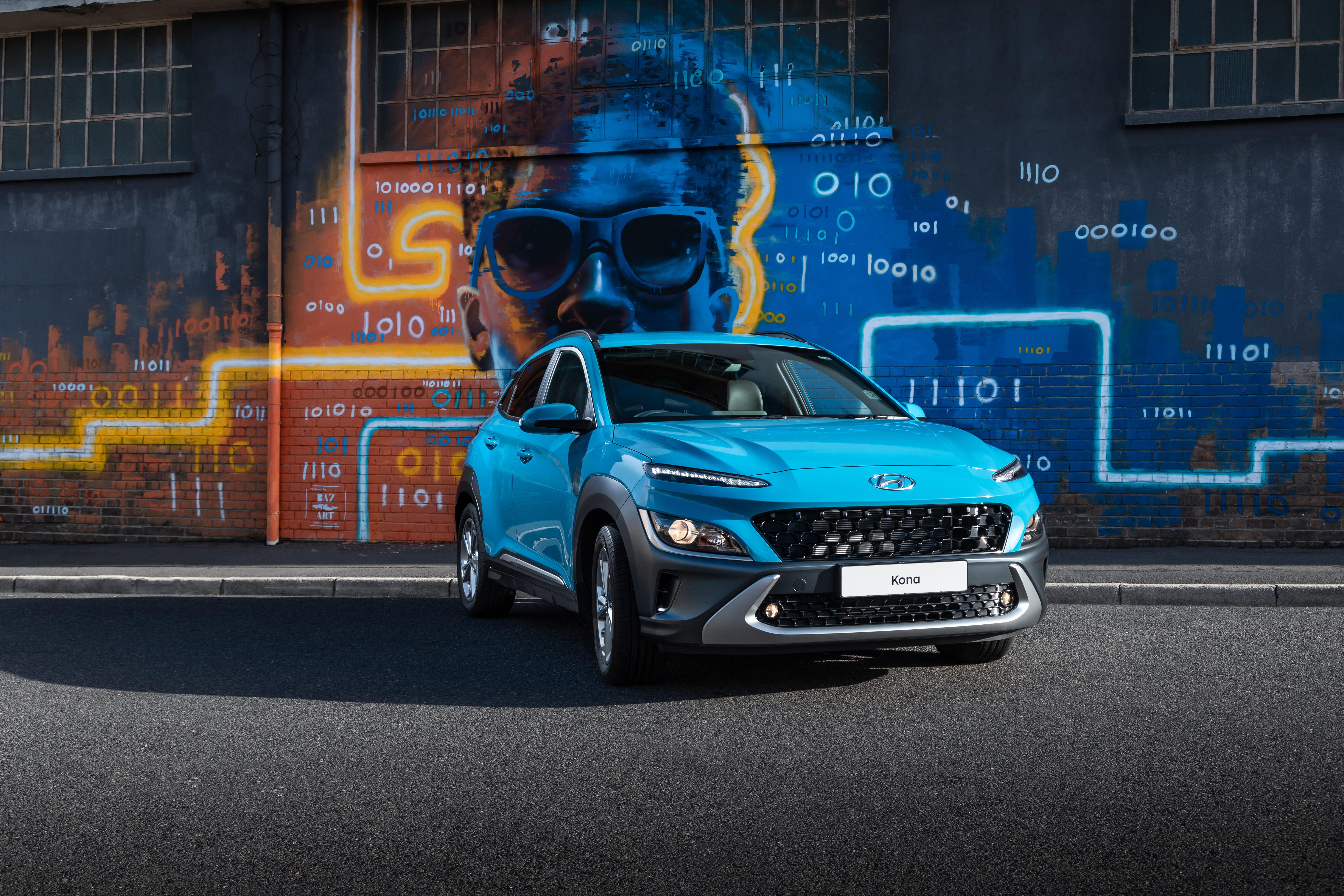 Blue 2021 Hyundai Kona SUV parked by graffiti wall HD Wallpaper