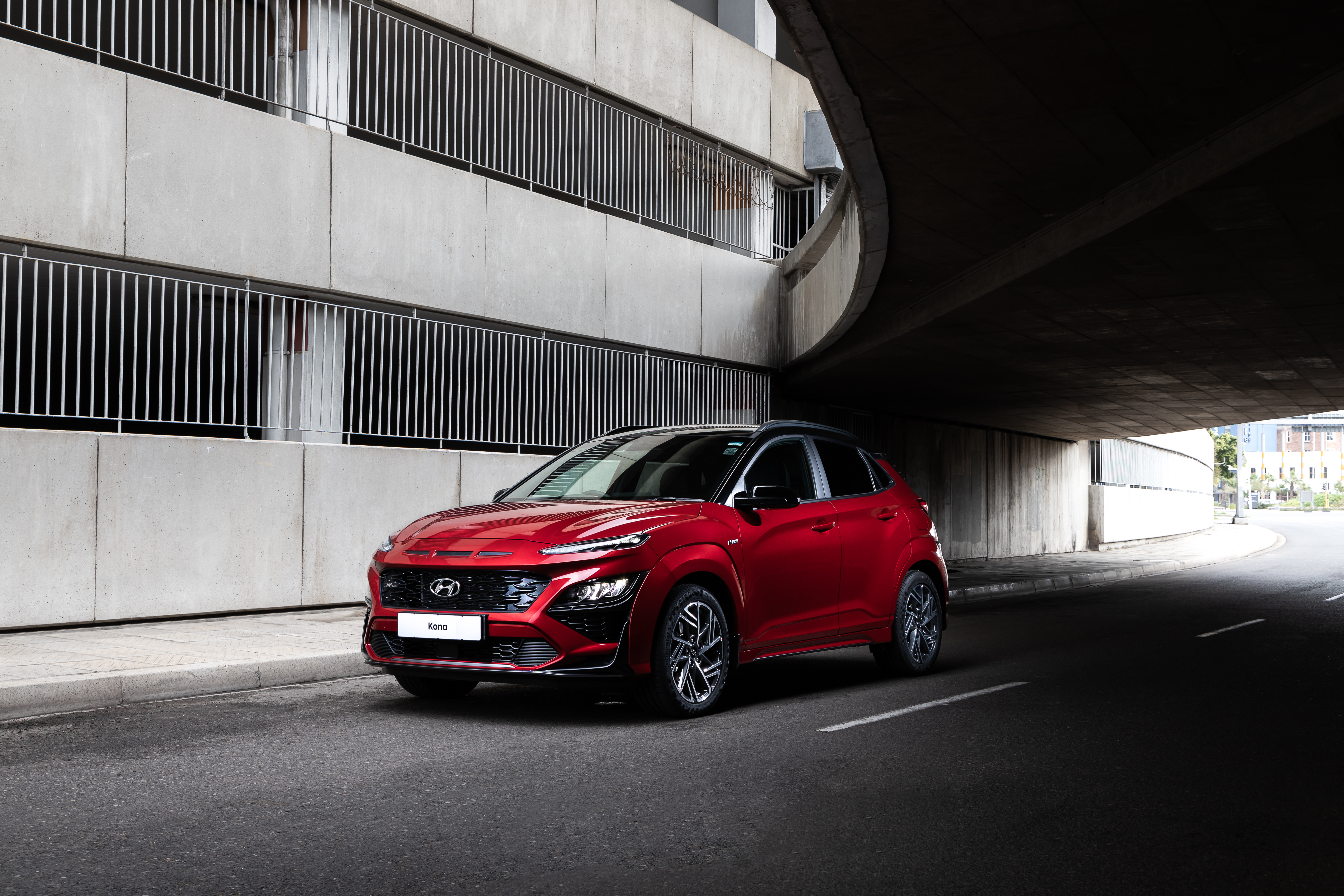 Red 2021 Hyundai Kona N Line SUV parked under bridge HD Wallpaper