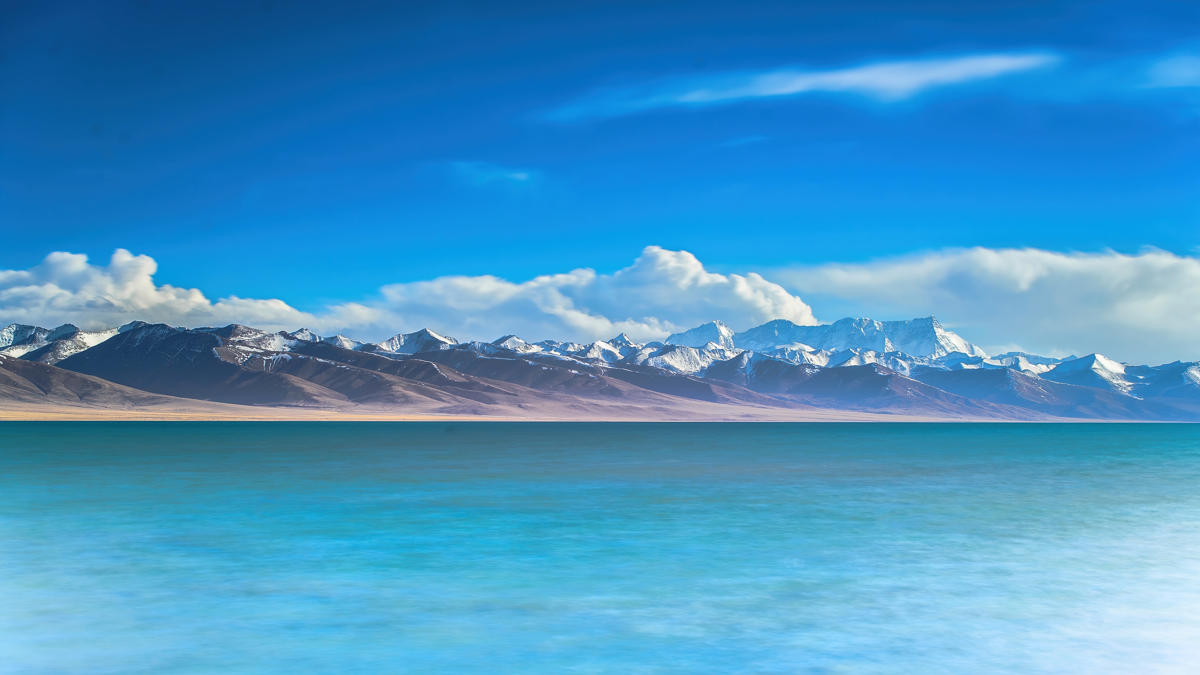 Turquoise lake and snow-capped mountains under blue sky HD Wallpaper