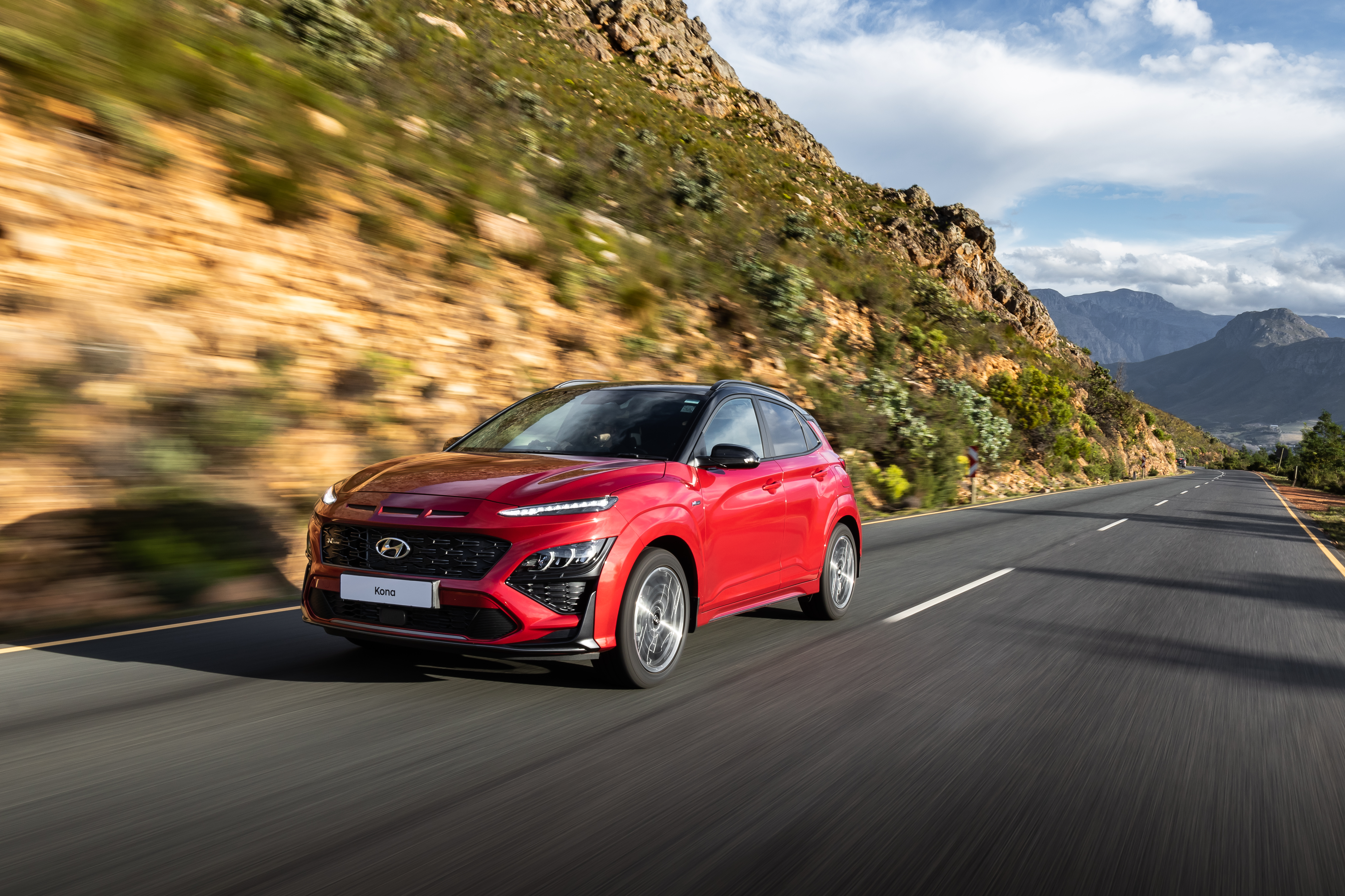 Red 2021 Hyundai Kona N Line driving on mountain road HD Wallpaper