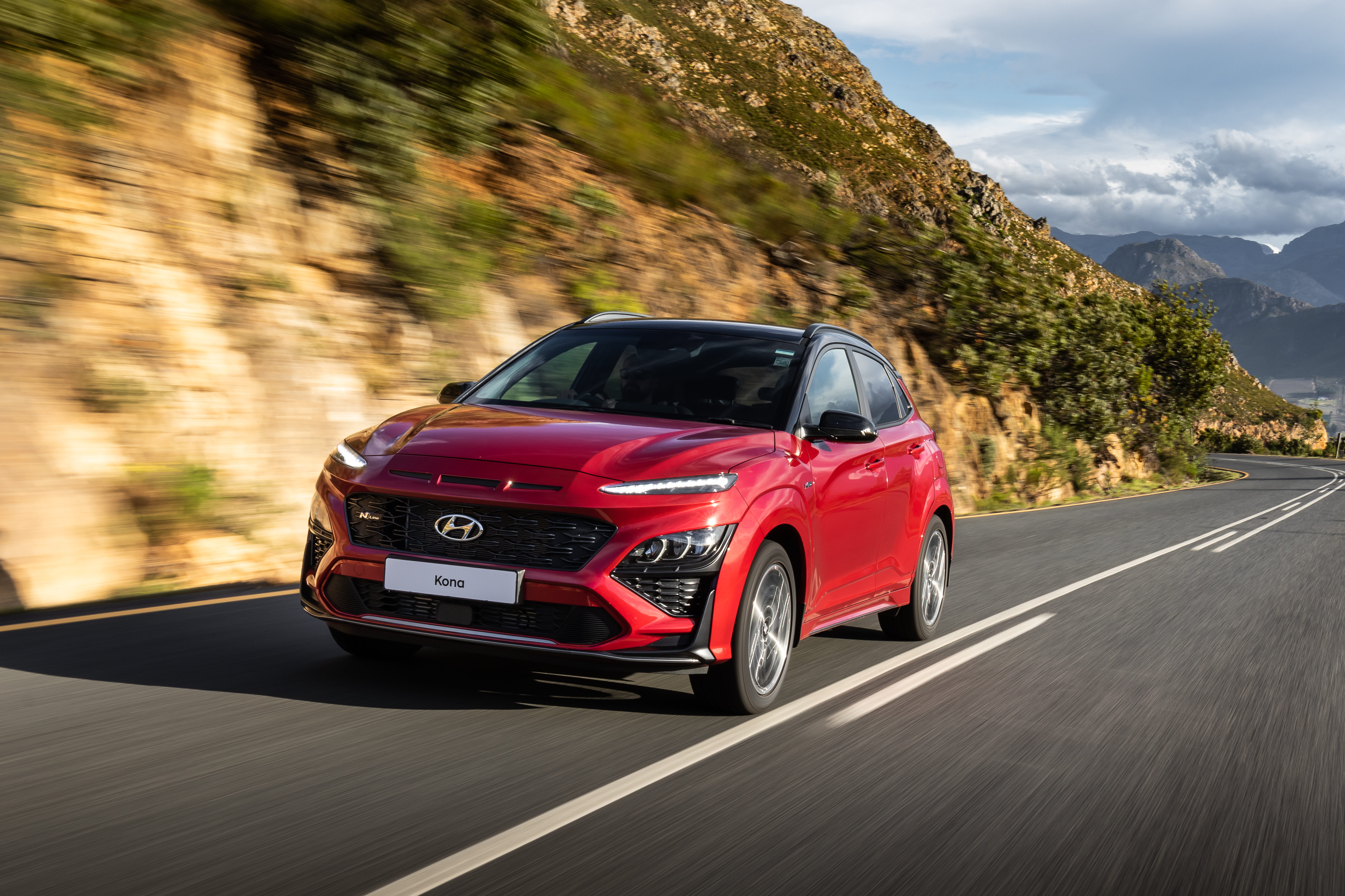 Red 2021 Hyundai Kona N Line SUV on mountain road HD Wallpaper
