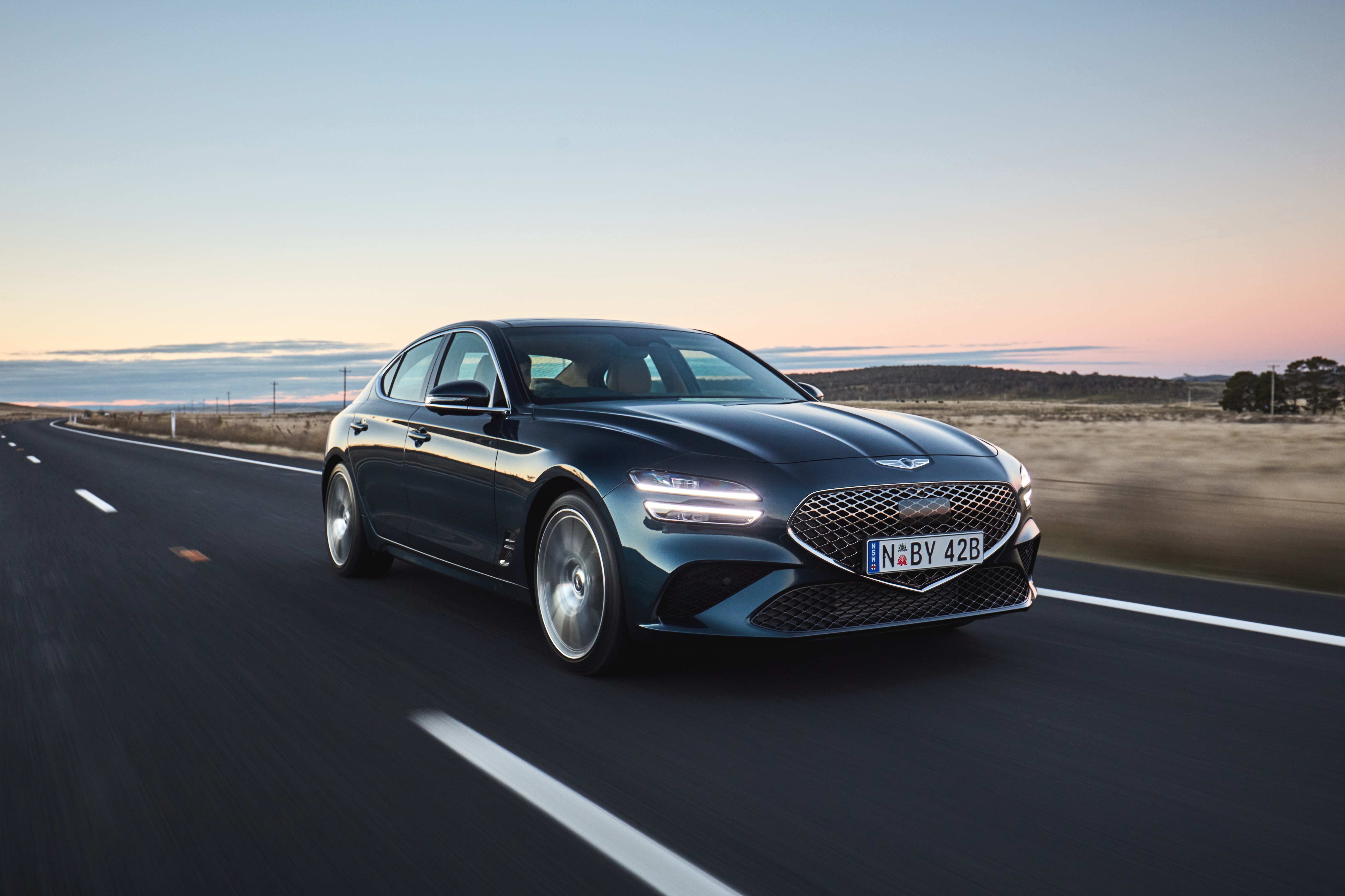 Blue 2021 Genesis G70 2.0T driving on a road HD Wallpaper