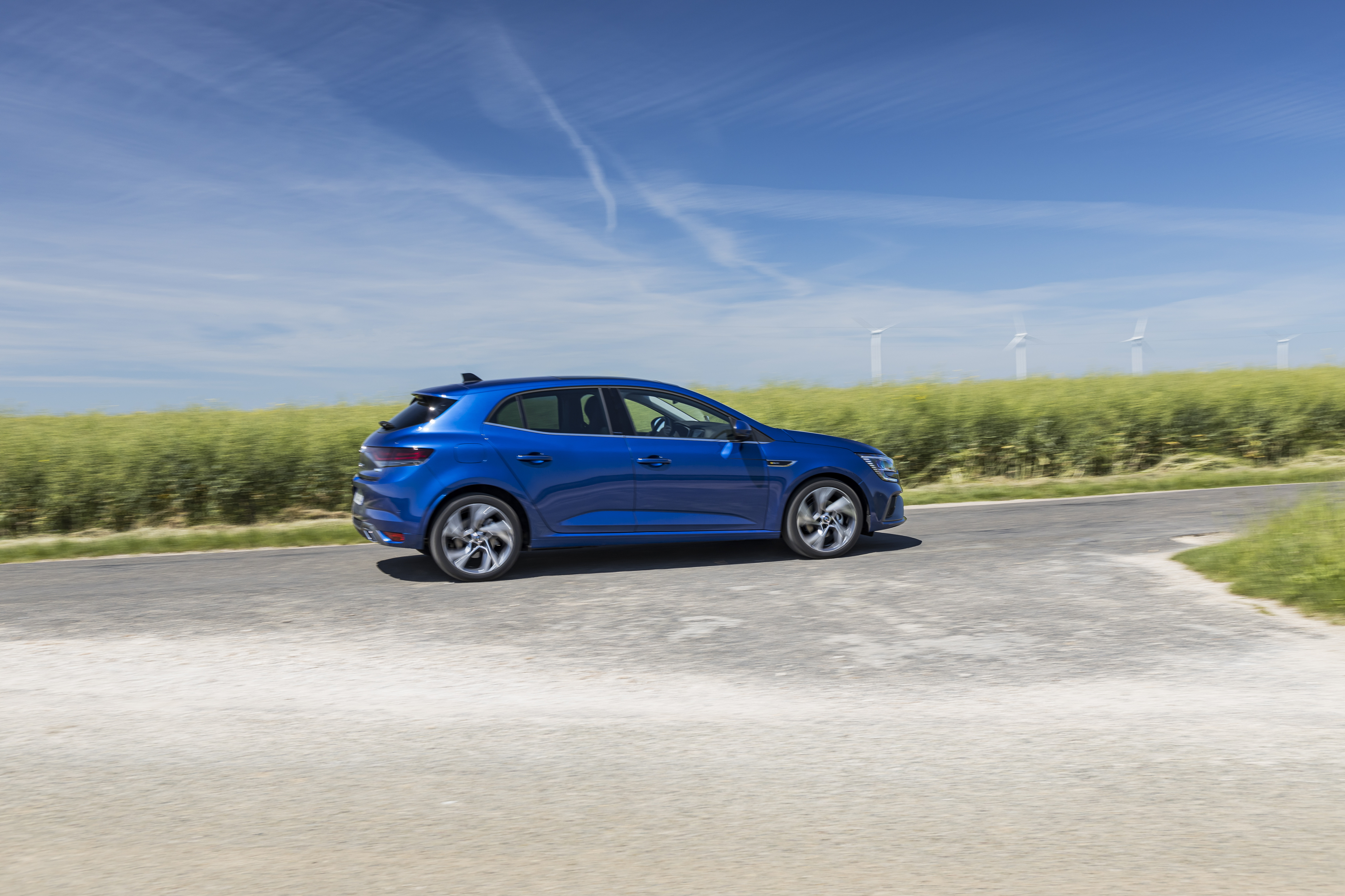 Blue Renault Mégane E-TECH driving on a road HD Wallpaper