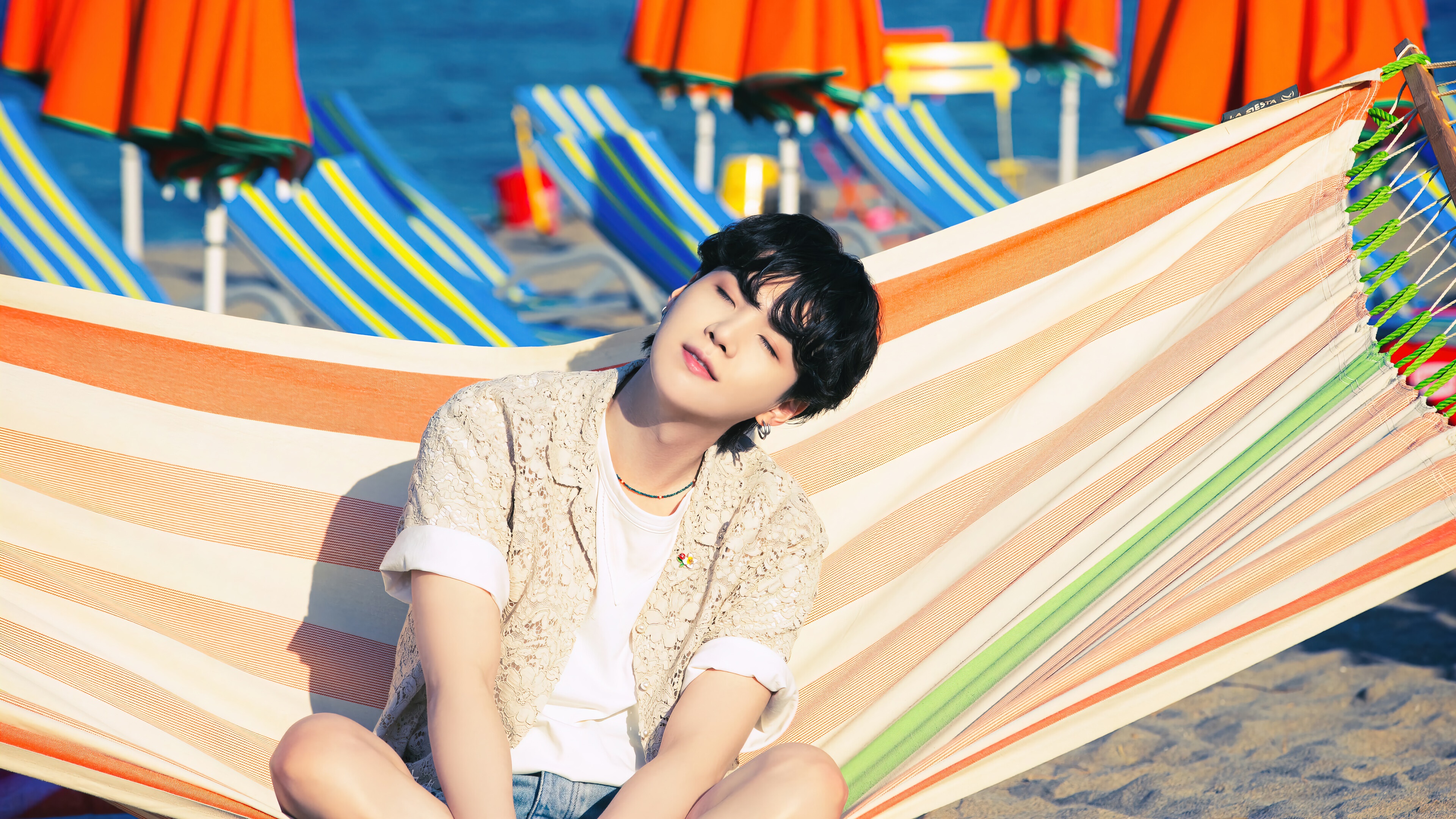 Suga from BTS relaxing on a beach hammock HD Wallpaper