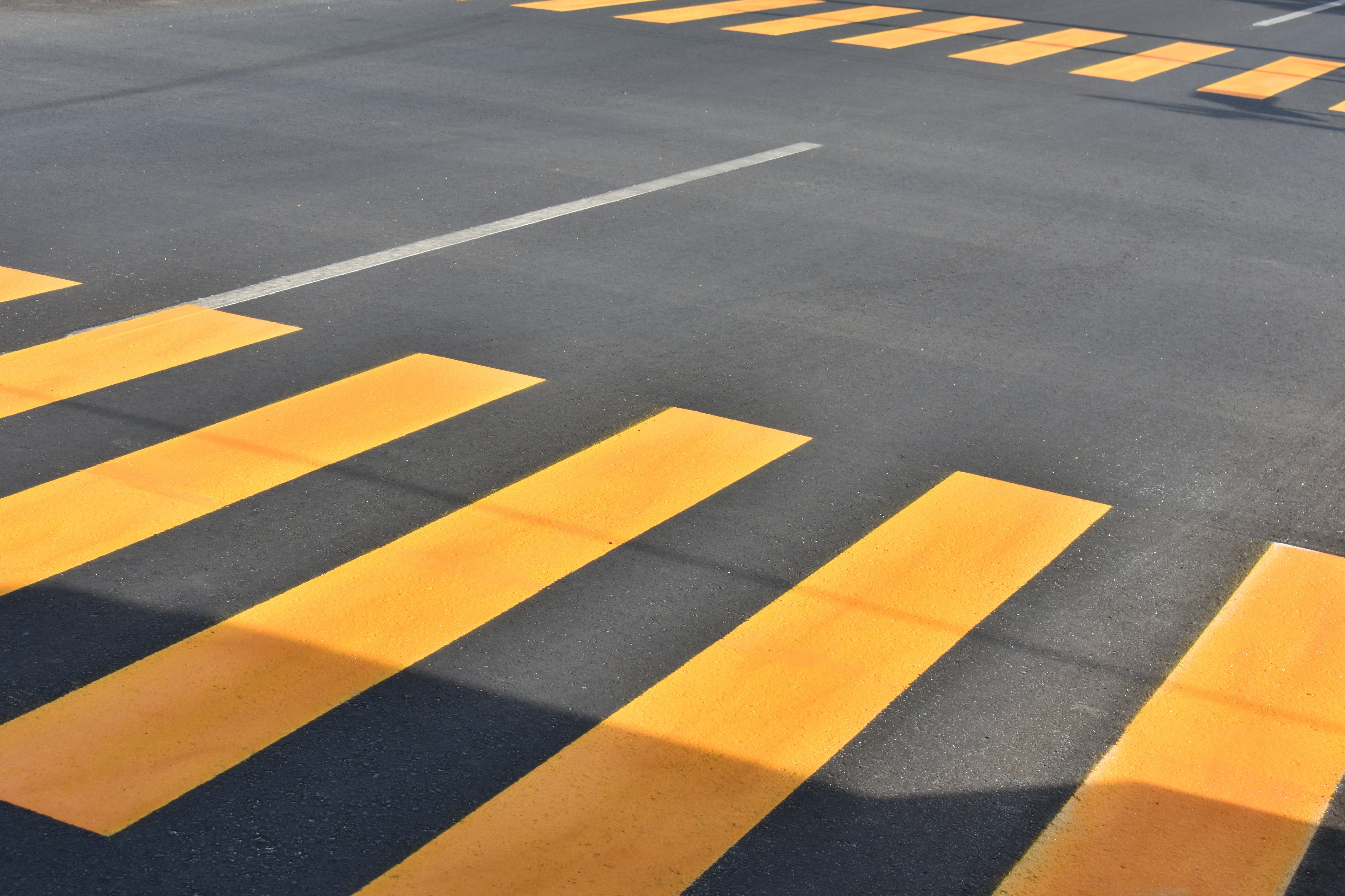 Yellow crosswalk stripes on asphalt road HD Wallpaper