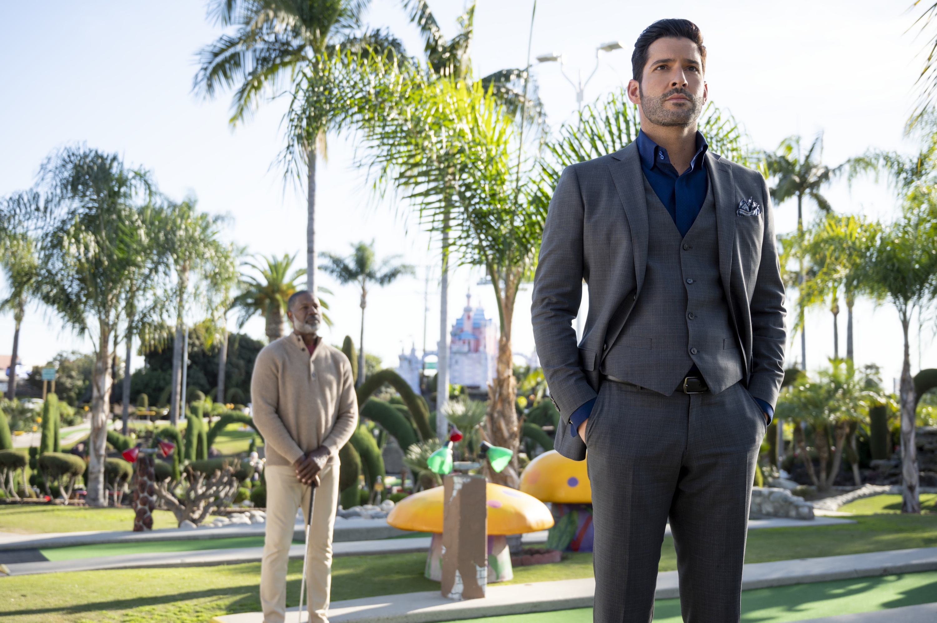 Tom Ellis in a suit at a miniature golf course HD Wallpaper