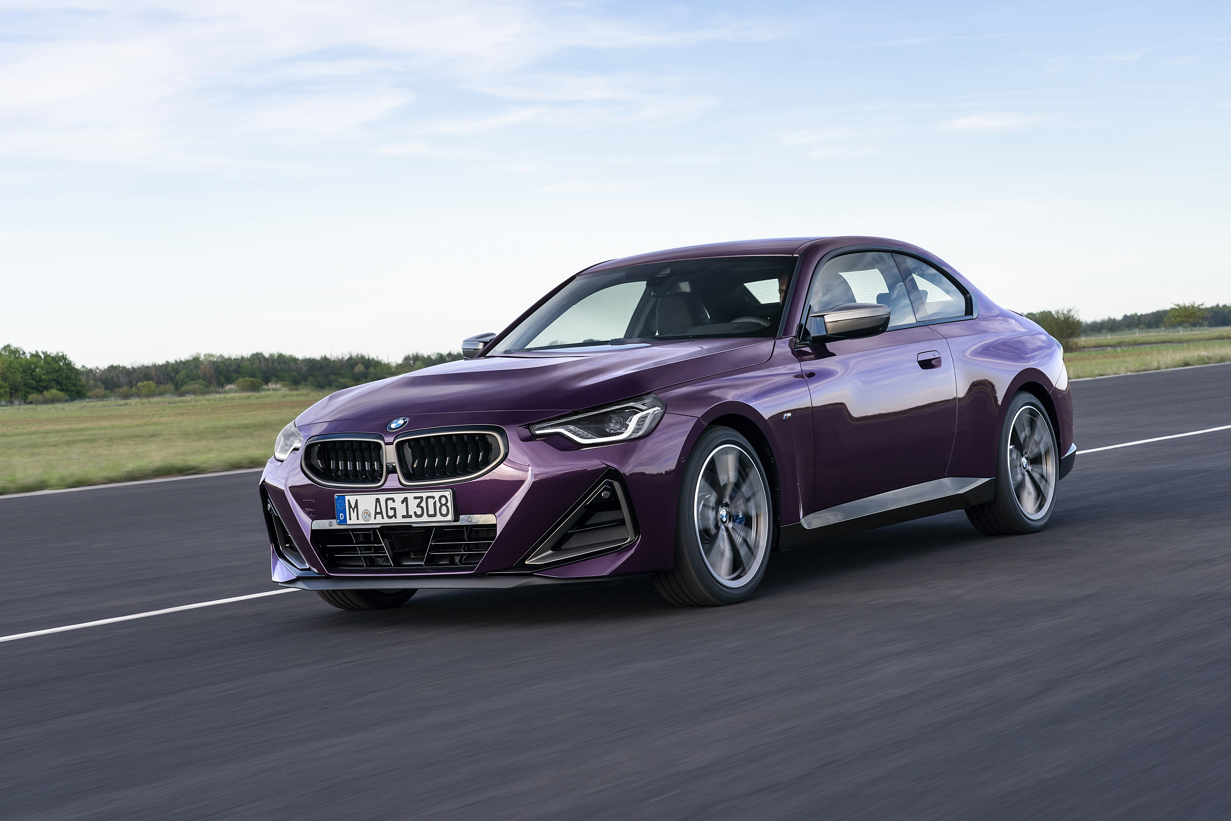 Purple BMW M240i xDrive Coupé driving on a road HD Wallpaper
