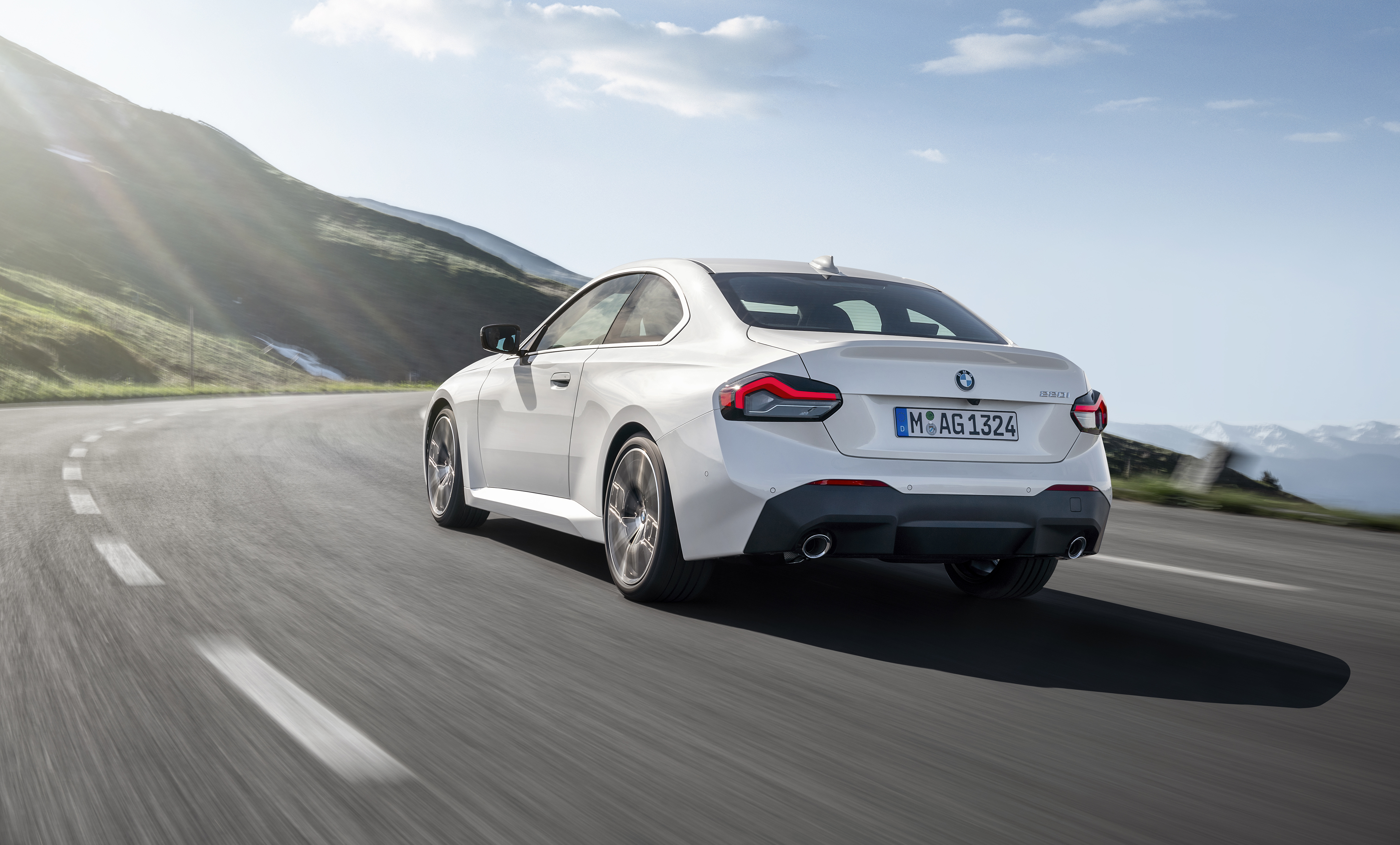 White BMW 220i Coupe driving on a scenic mountain road HD Wallpaper