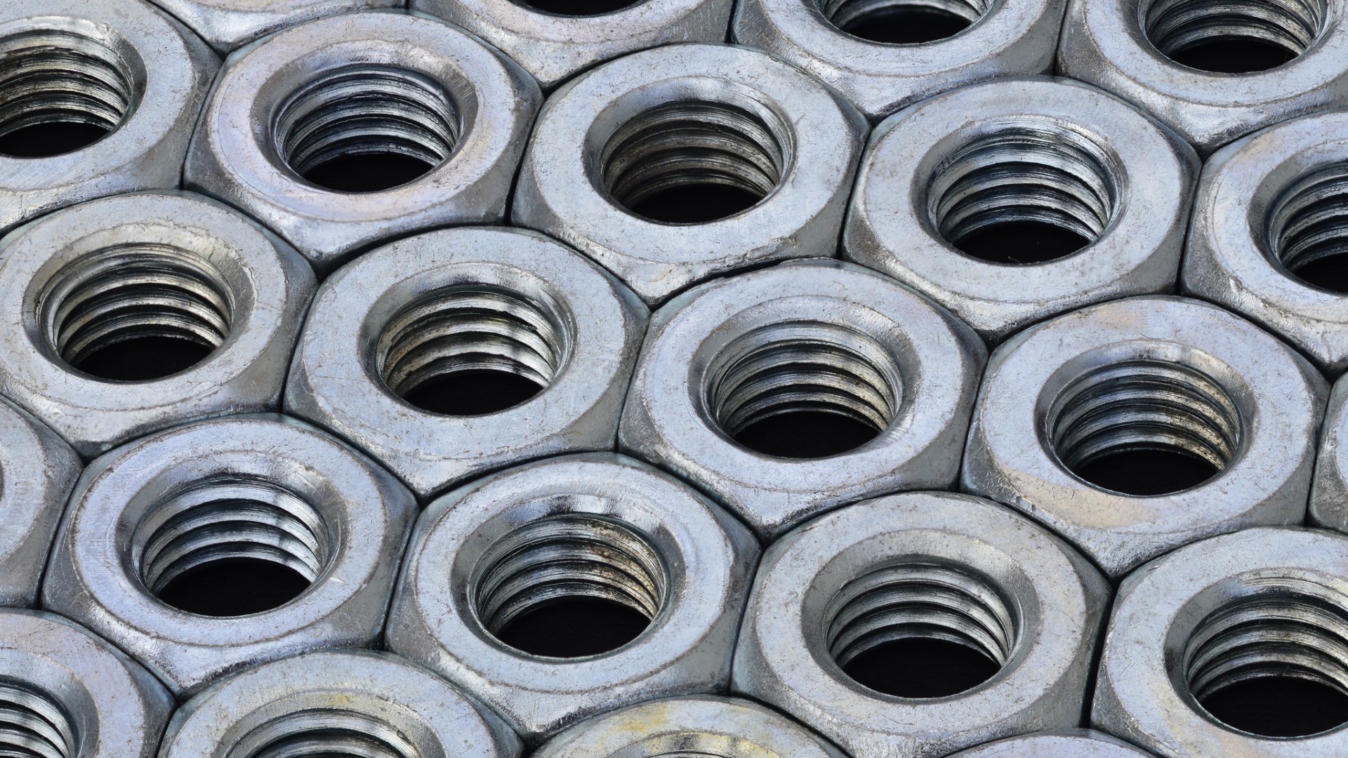 Close-up of a pile of metal nuts HD Wallpaper