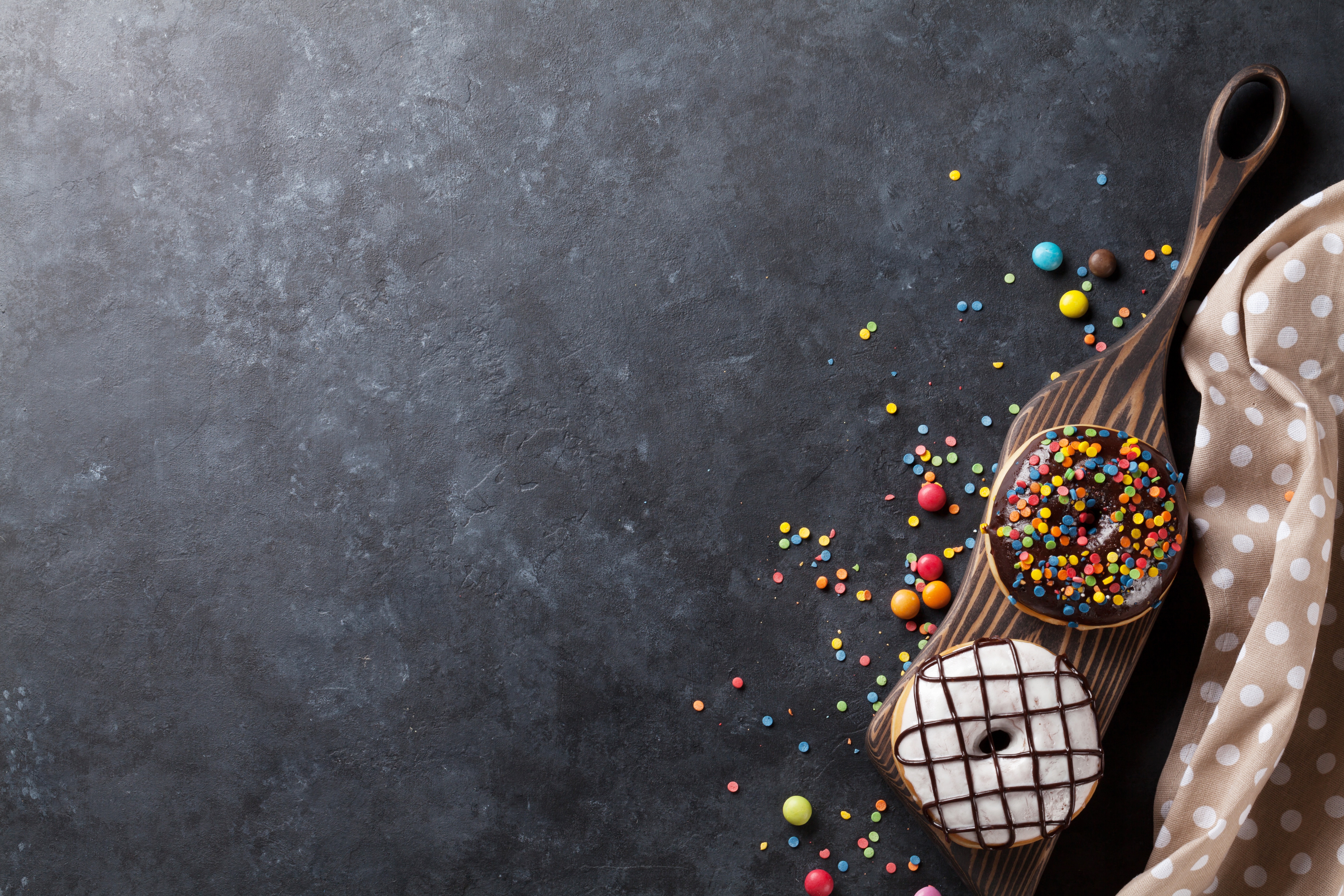 Two donuts with sprinkles and chocolate on a wooden board HD Wallpaper