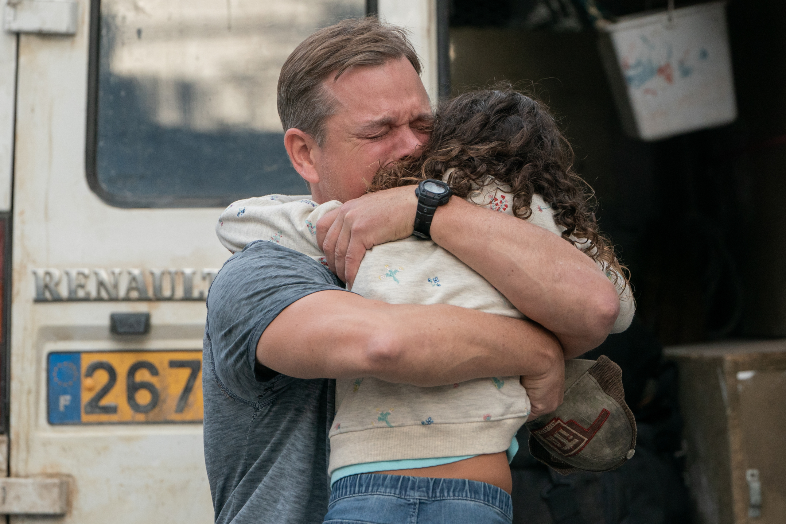 Matt Damon hugs a child in Stillwater HD Wallpaper