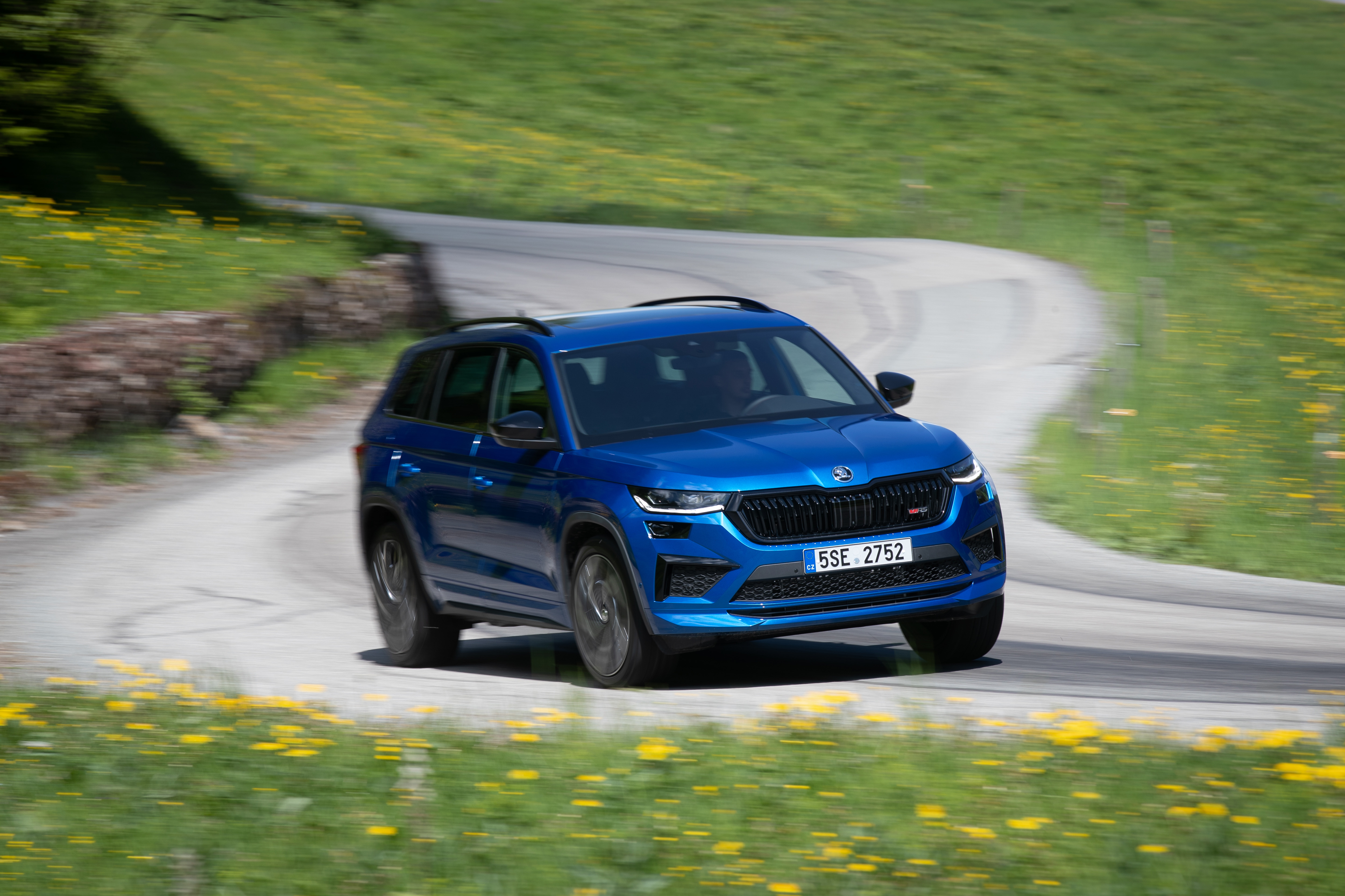 Blue Skoda Kodiaq RS driving on a winding road HD Wallpaper