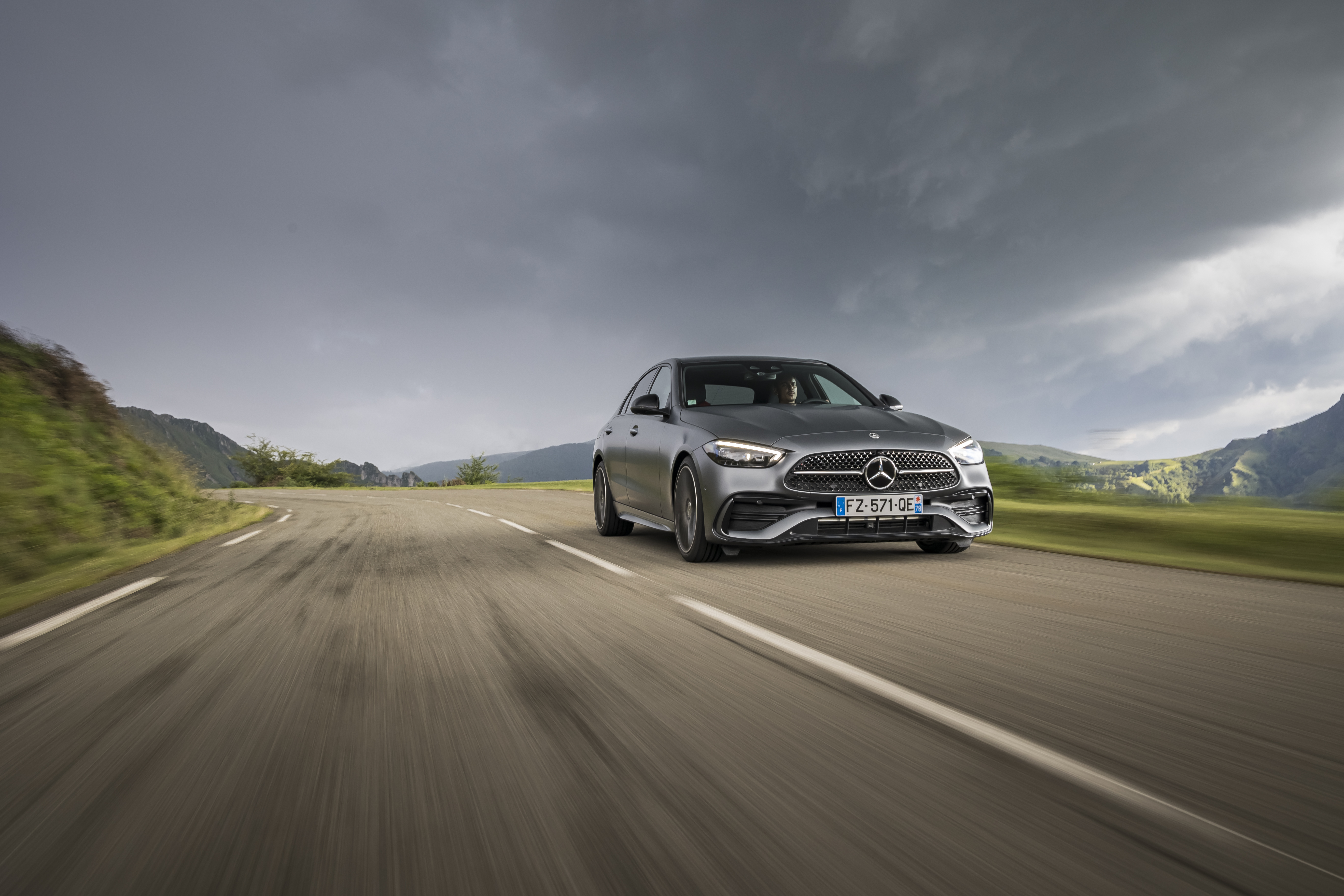 Grey Mercedes-Benz C 220 d AMG Line driving on a road HD Wallpaper