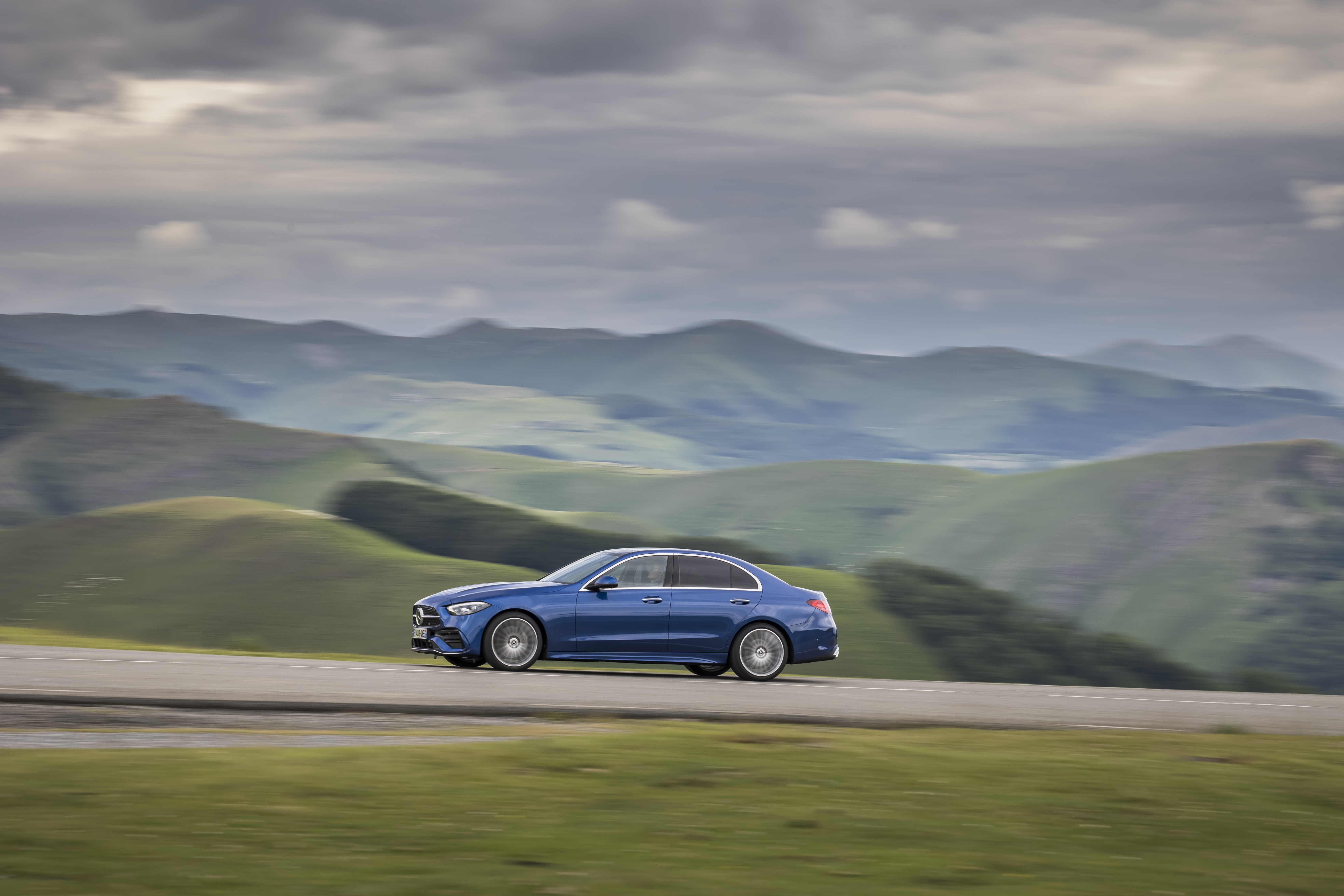 Blue Mercedes-Benz C 200 AMG Line on a mountain road HD Wallpaper