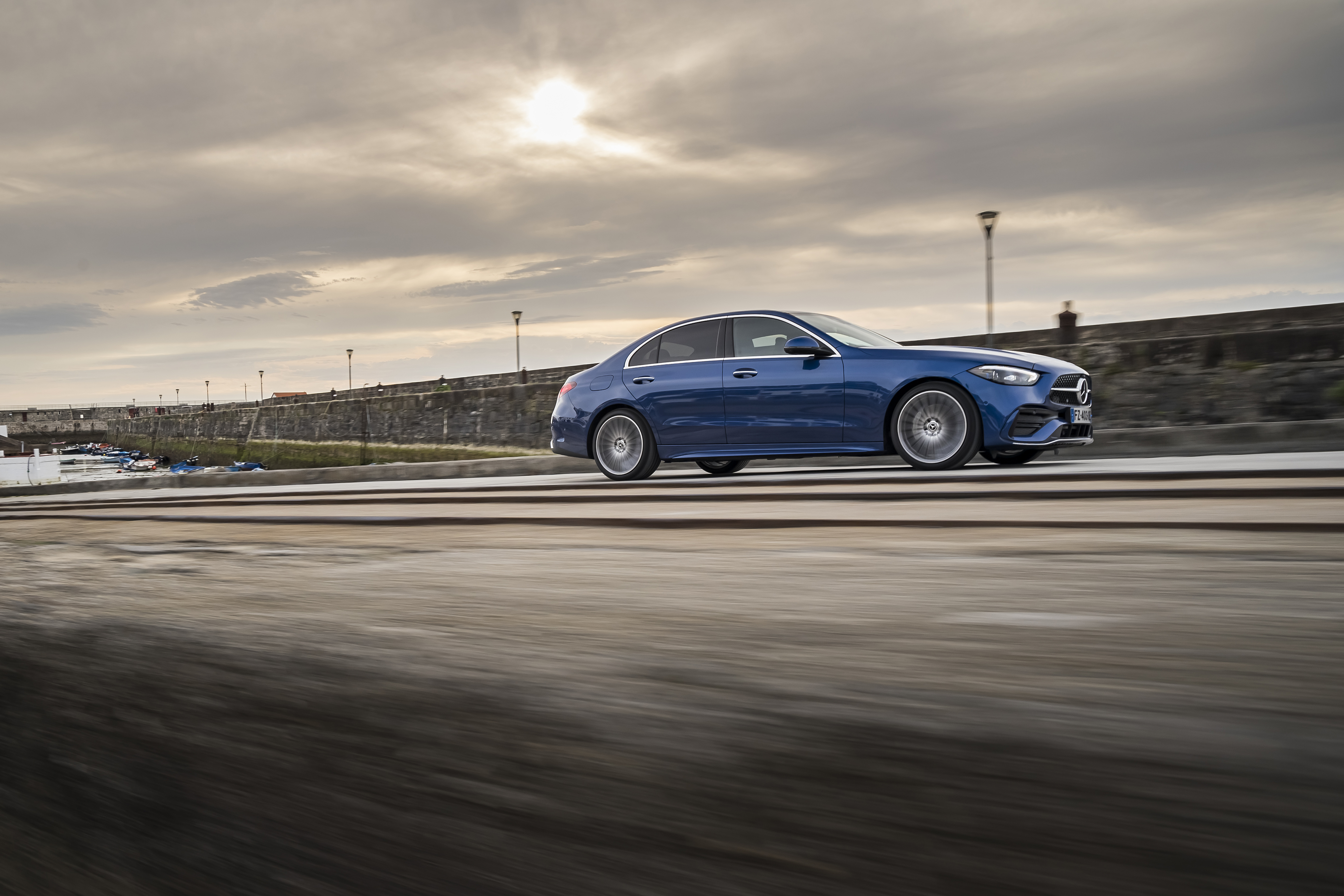 Blue Mercedes-Benz C 200 AMG Line driving by the sea HD Wallpaper
