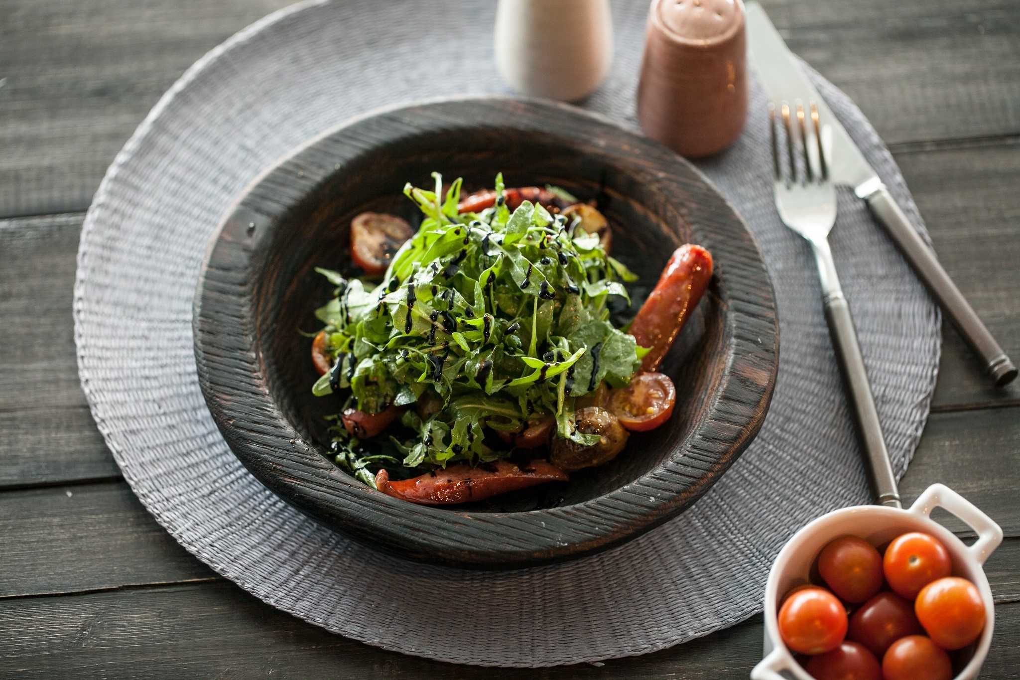 Salad with tomatoes and sausage on a wooden table HD Wallpaper