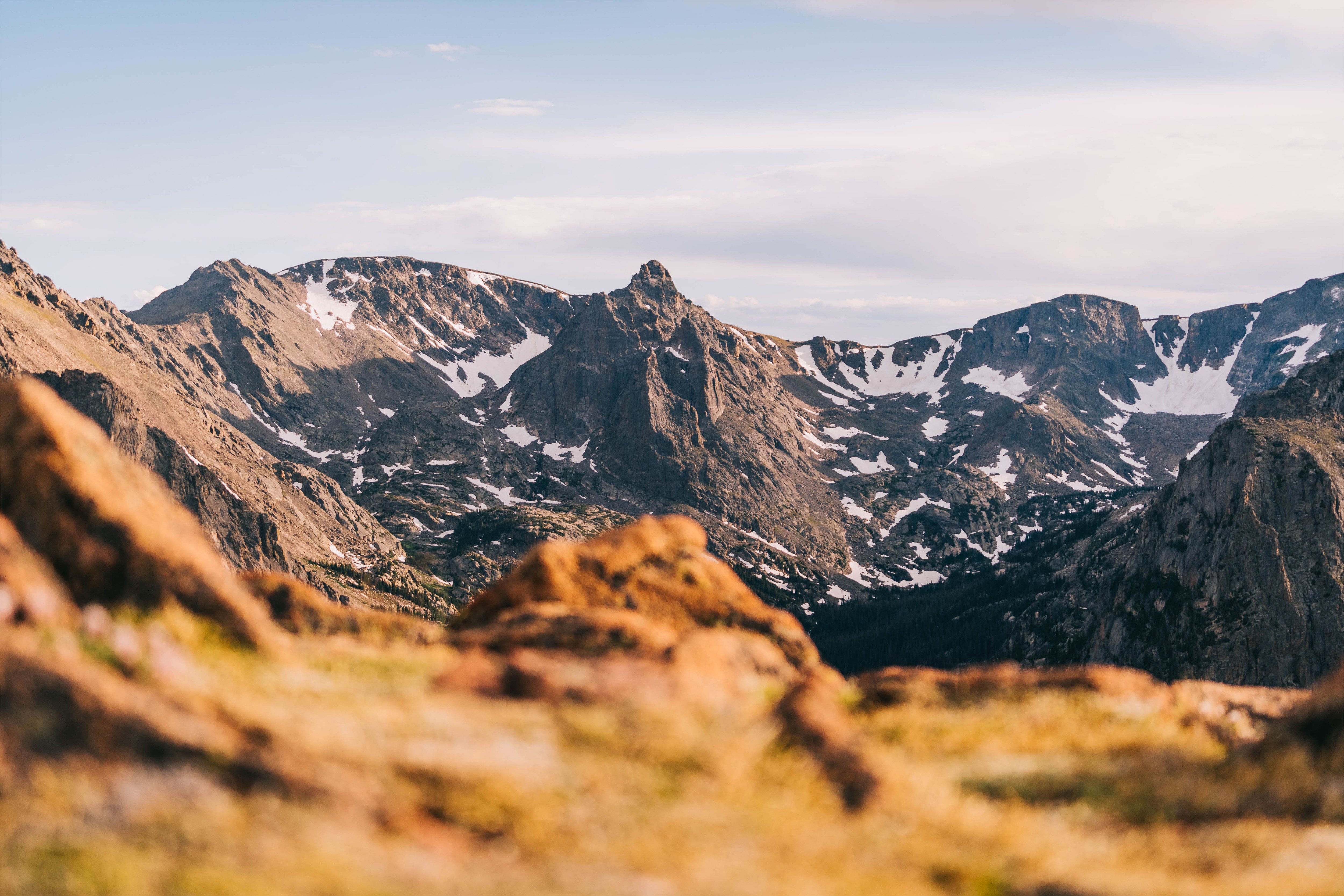 Snow-capped mountains under a cloudy sky HD Wallpaper