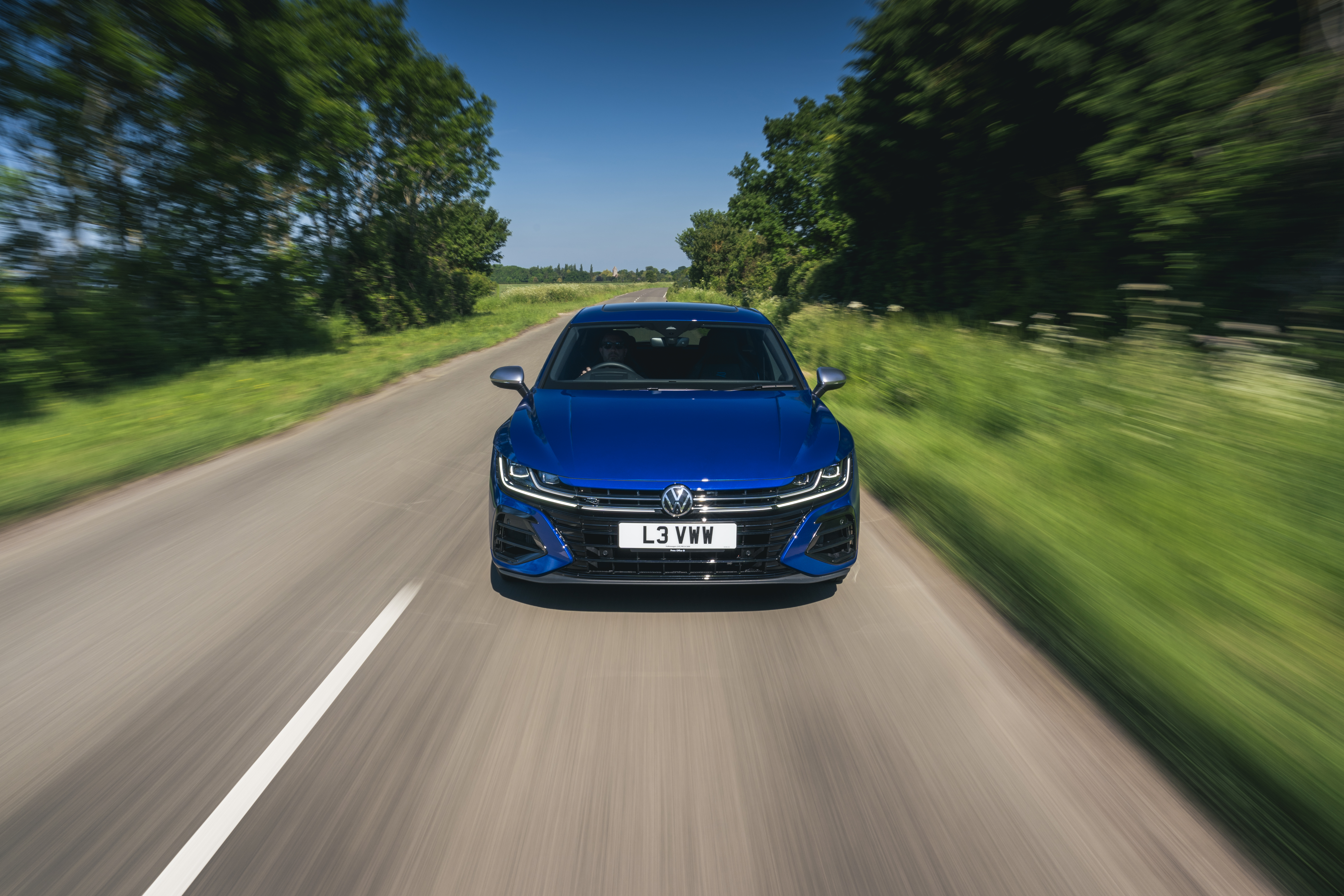 Blue Volkswagen Arteon driving on a country road HD Wallpaper