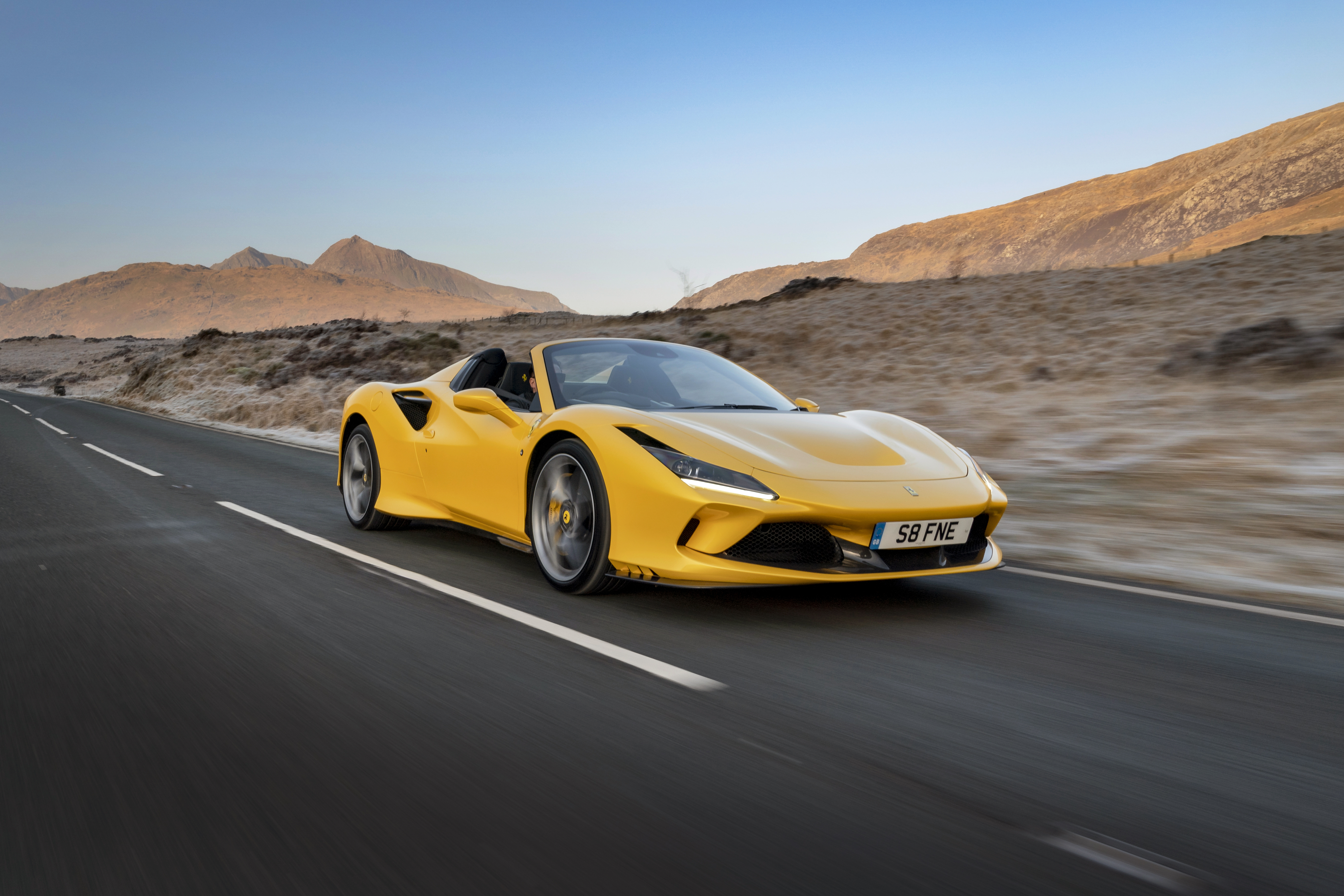 Yellow Ferrari F8 Spider driving on a road HD Wallpaper