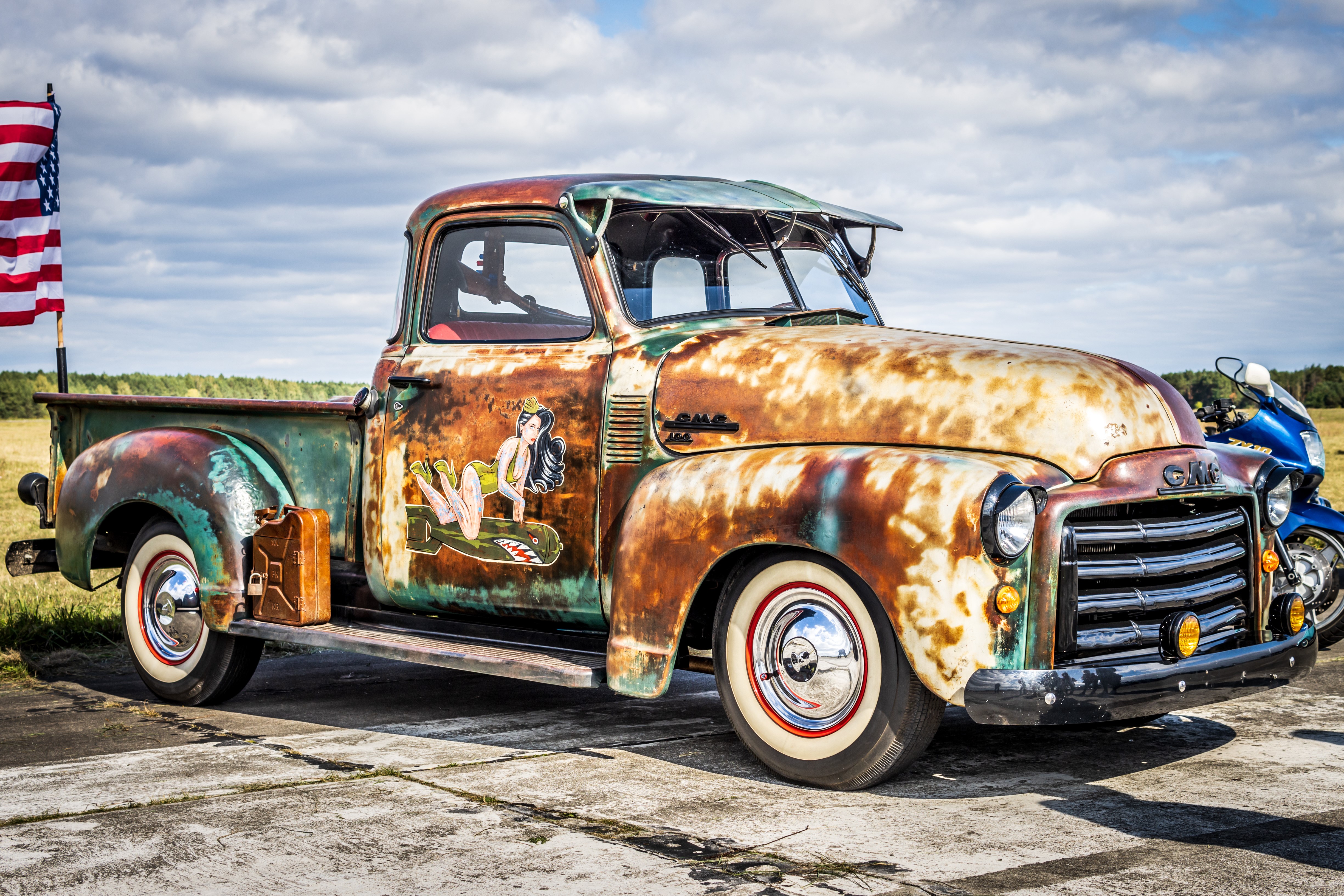 Rusted GMC pickup truck with pin-up art and American flag HD Wallpaper