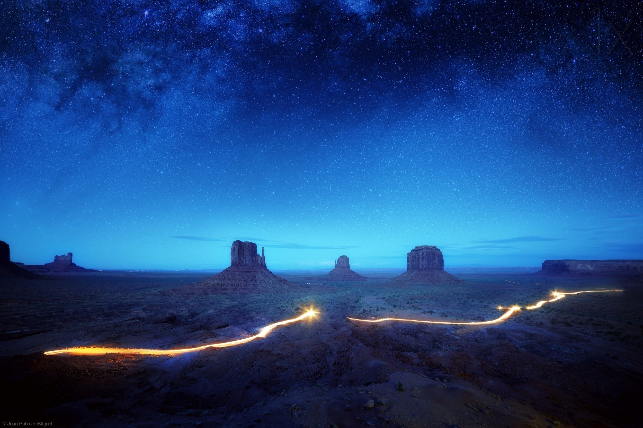 Monument Valley at night under the stars with light trails HD Wallpaper