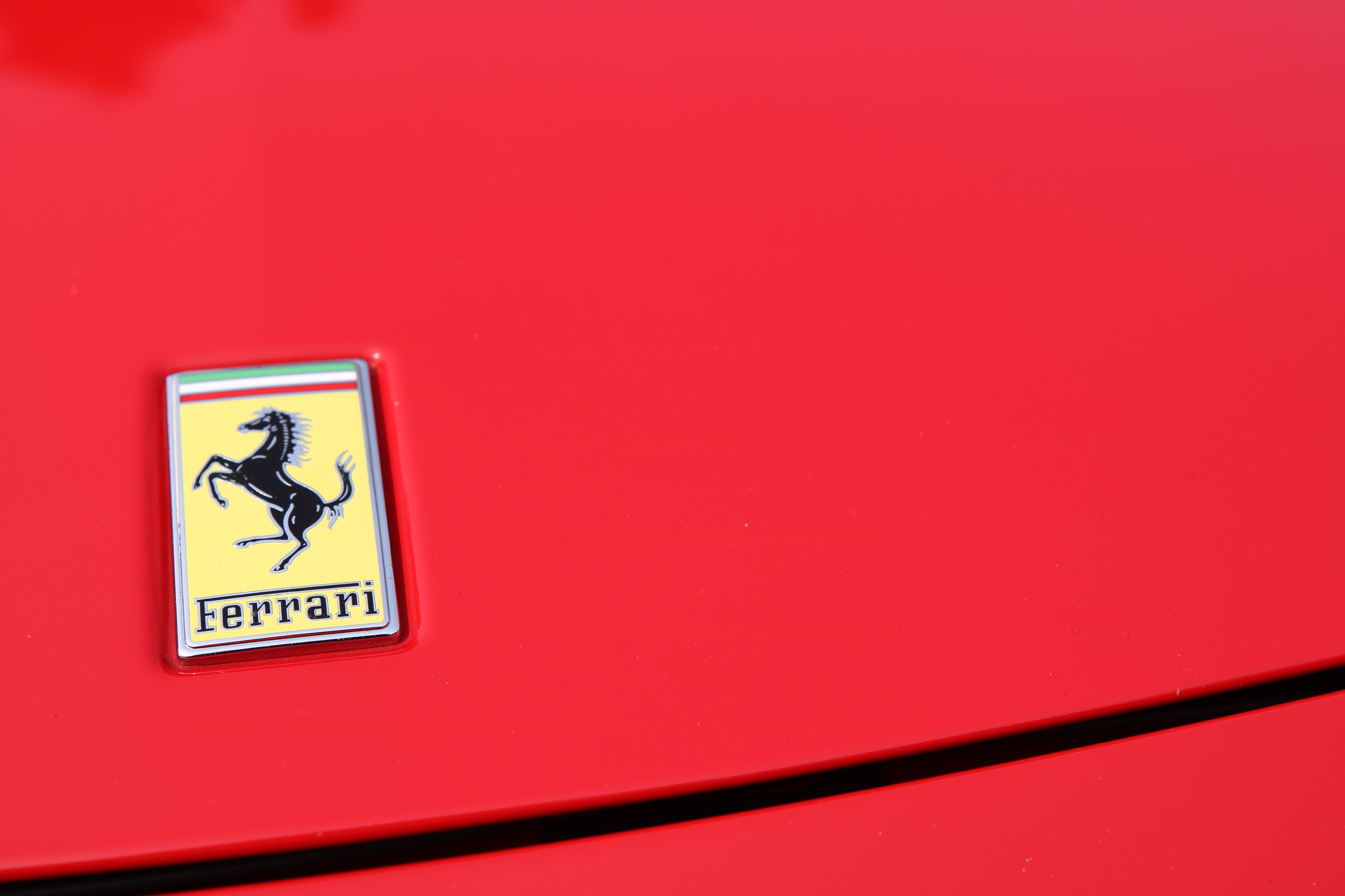 Ferrari logo on red car HD Wallpaper