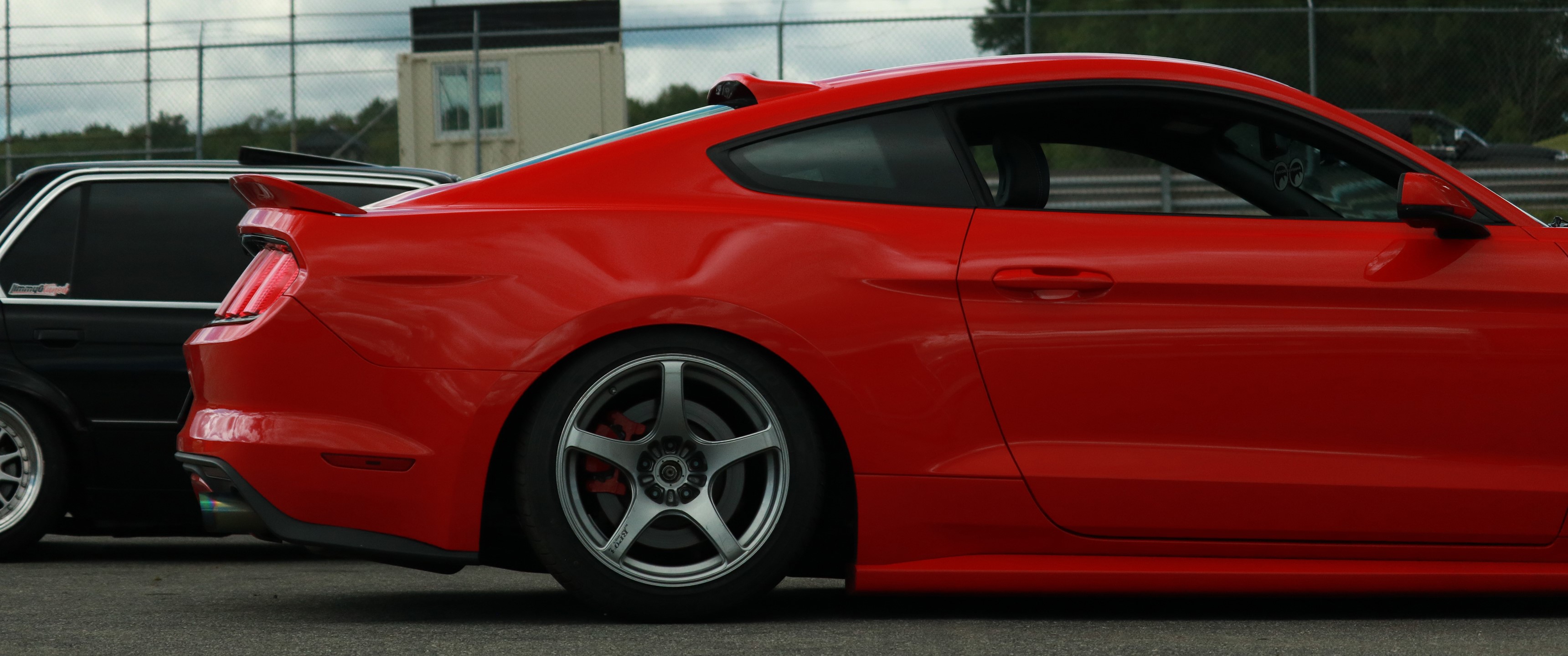 Red Ford Mustang parked next to black car HD Wallpaper