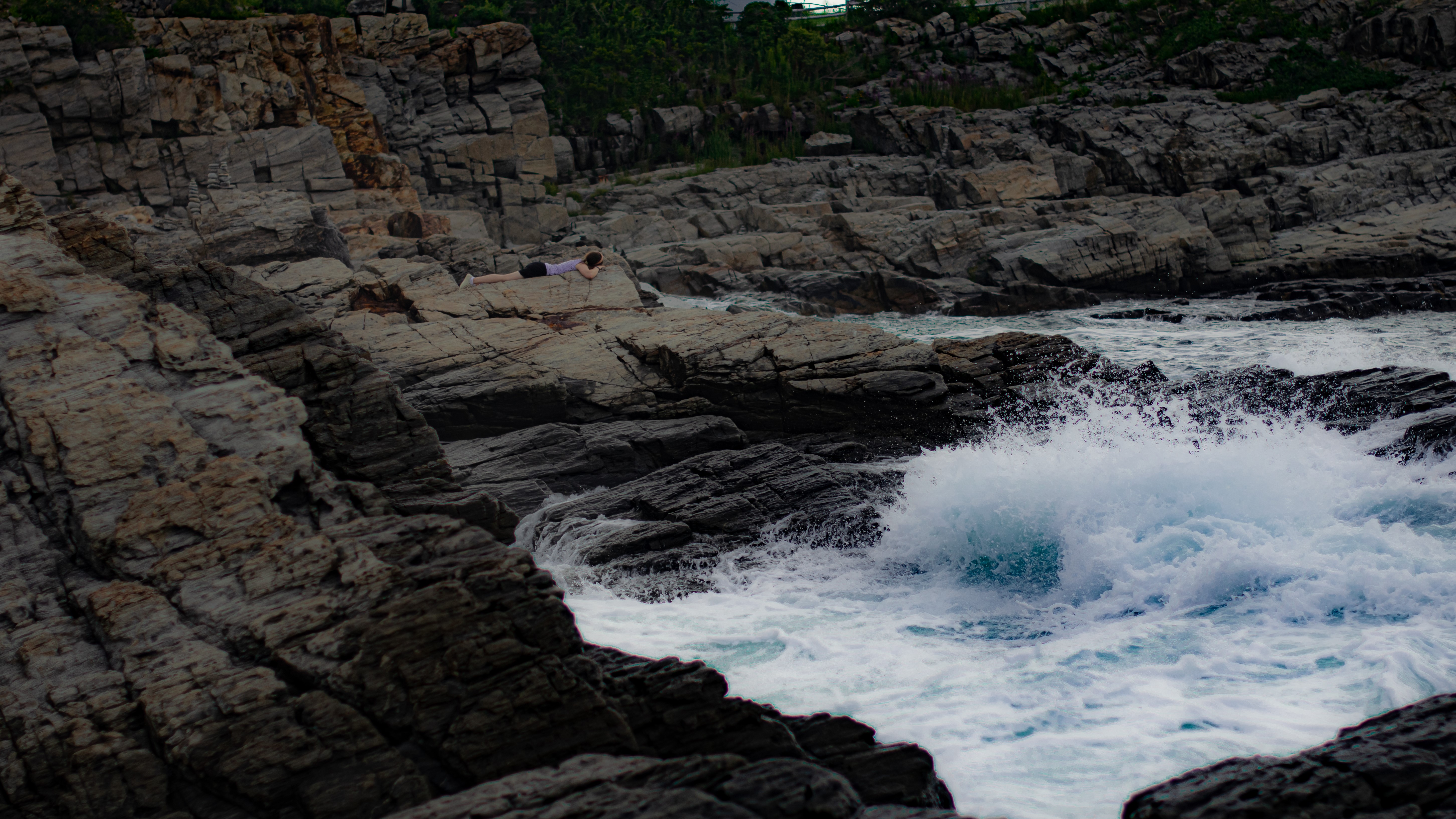 4K, purple shirt, lying down, women, rock formation, coastline, waves, black skirts, coast HD Wallpaper