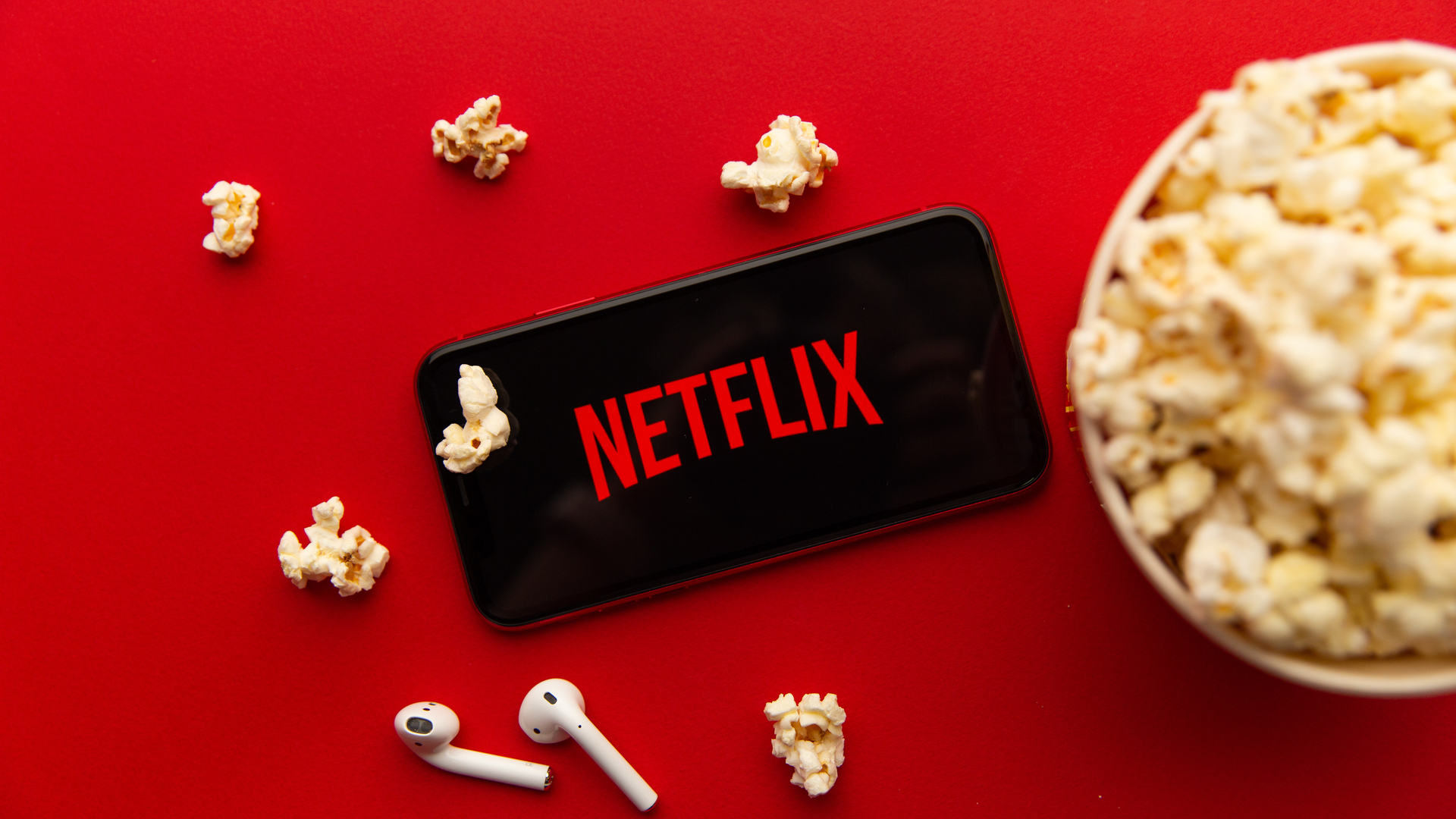 Netflix smartphone with popcorn and earbuds HD Wallpaper