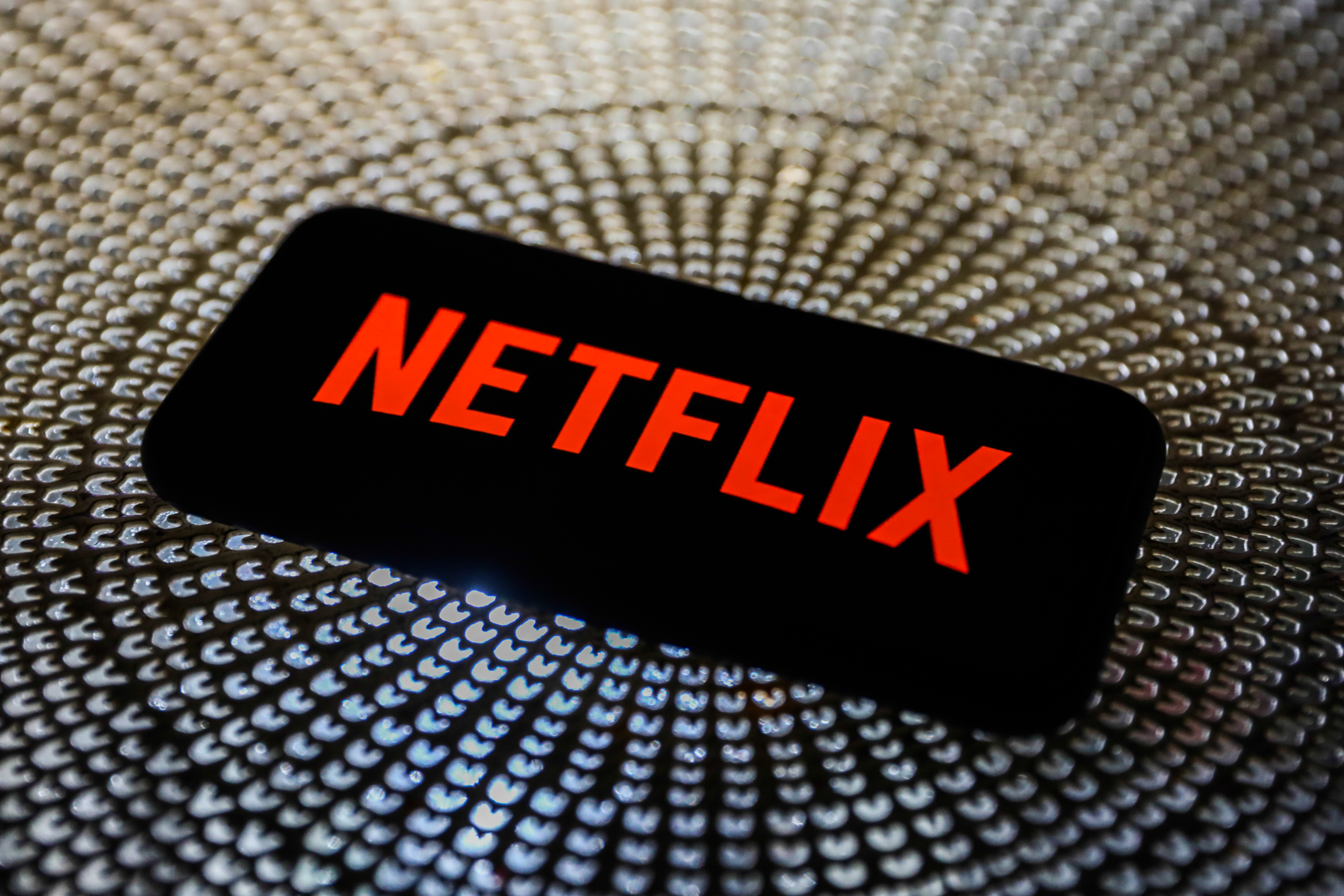 Netflix logo on a smartphone HD Wallpaper