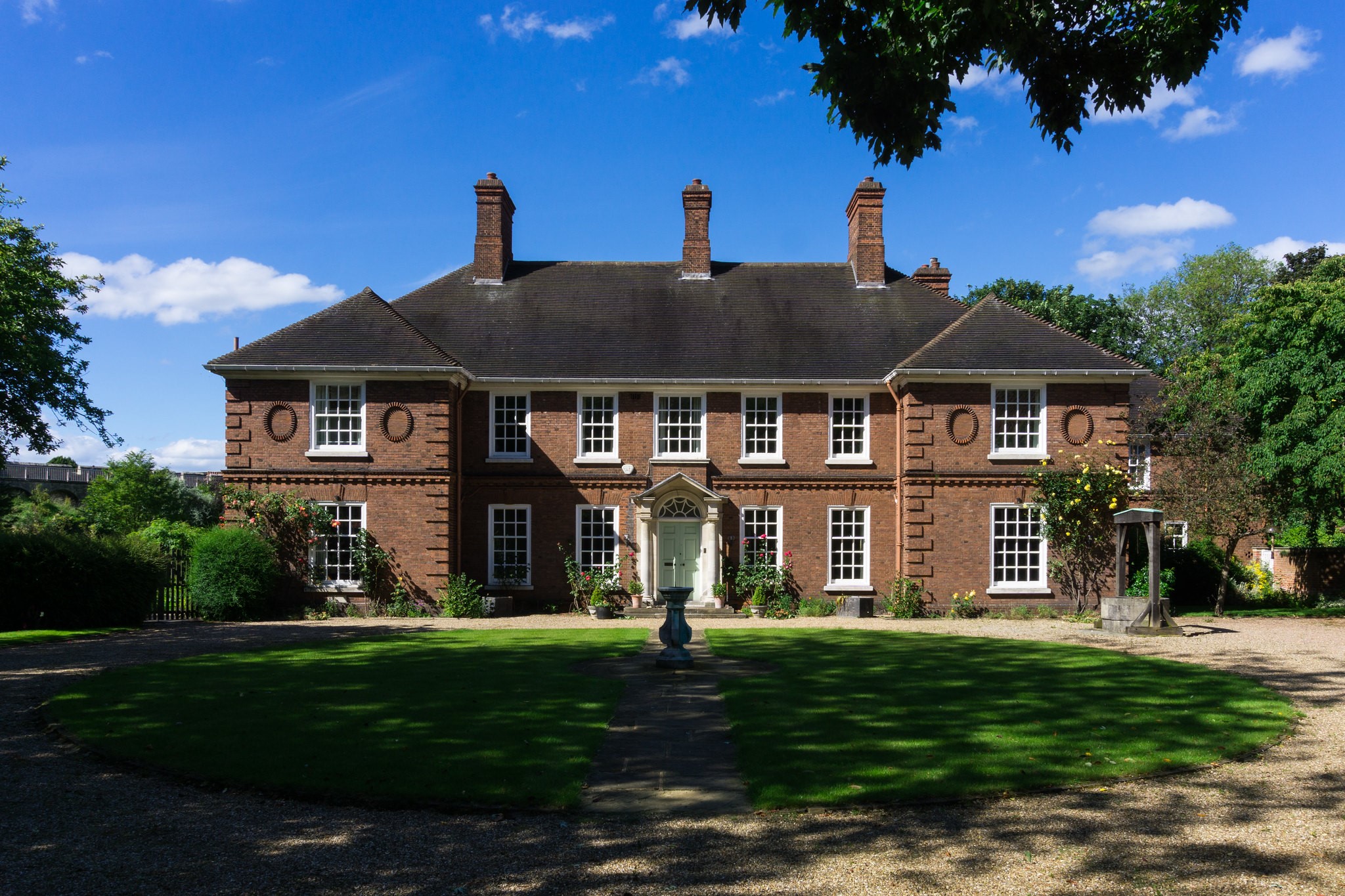 Brick mansion with manicured lawn and trees HD Wallpaper