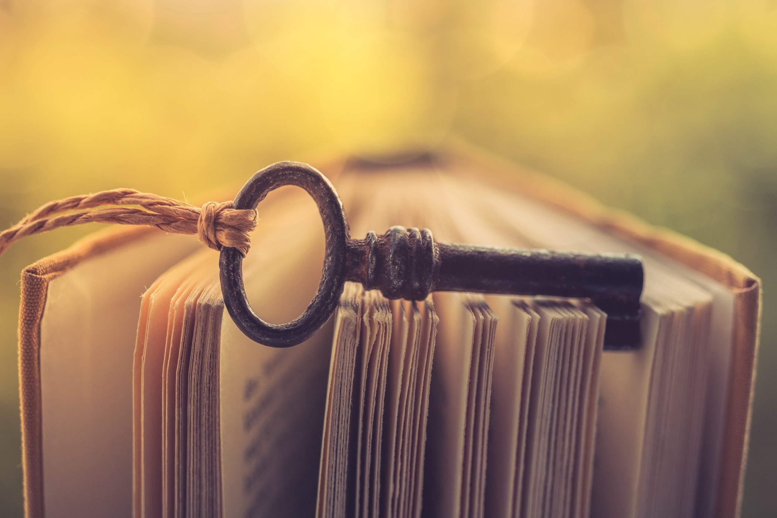 Antique key on an open book HD Wallpaper