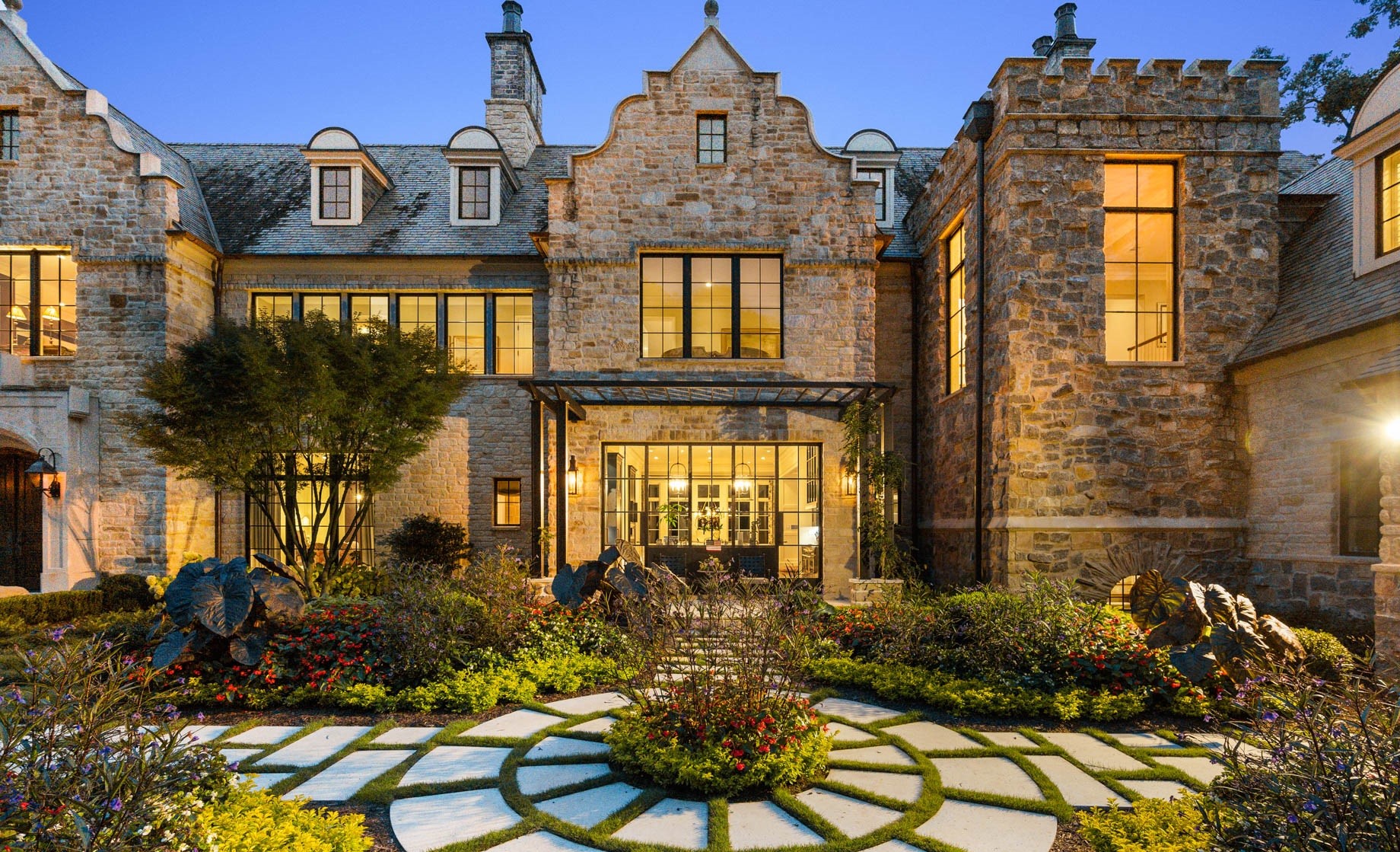 Stone mansion with formal garden and circular pathway HD Wallpaper