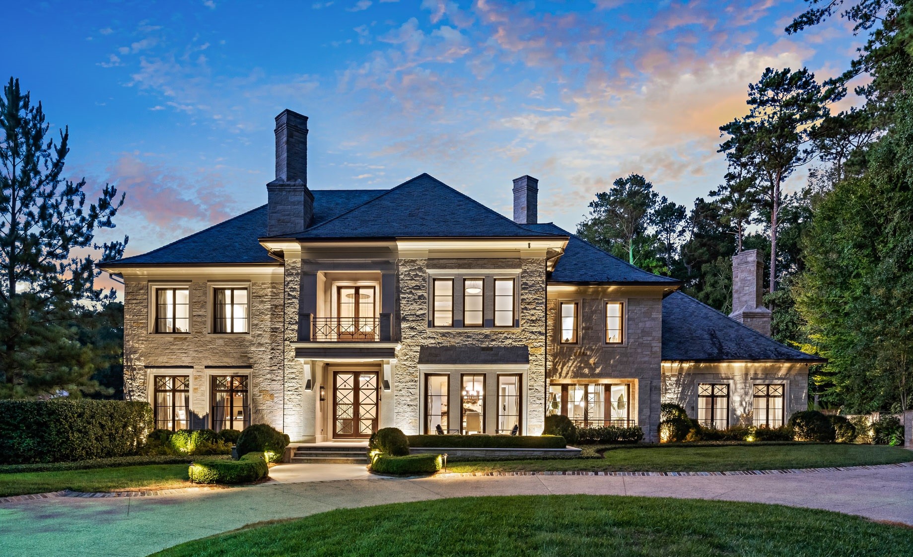 Luxury stone mansion with illuminated facade at dusk HD Wallpaper