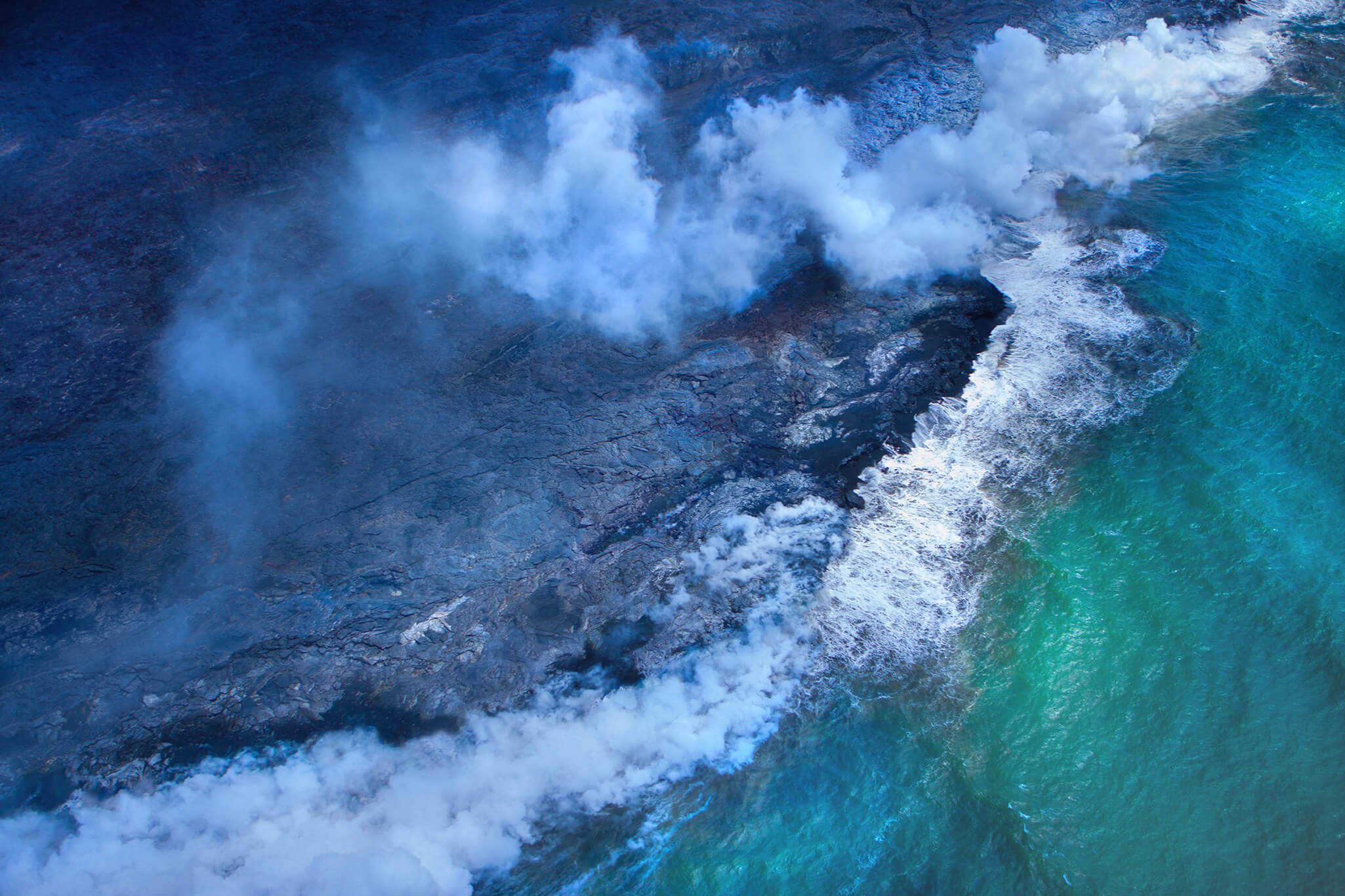 Aerial view of lava flowing into the sea HD Wallpaper