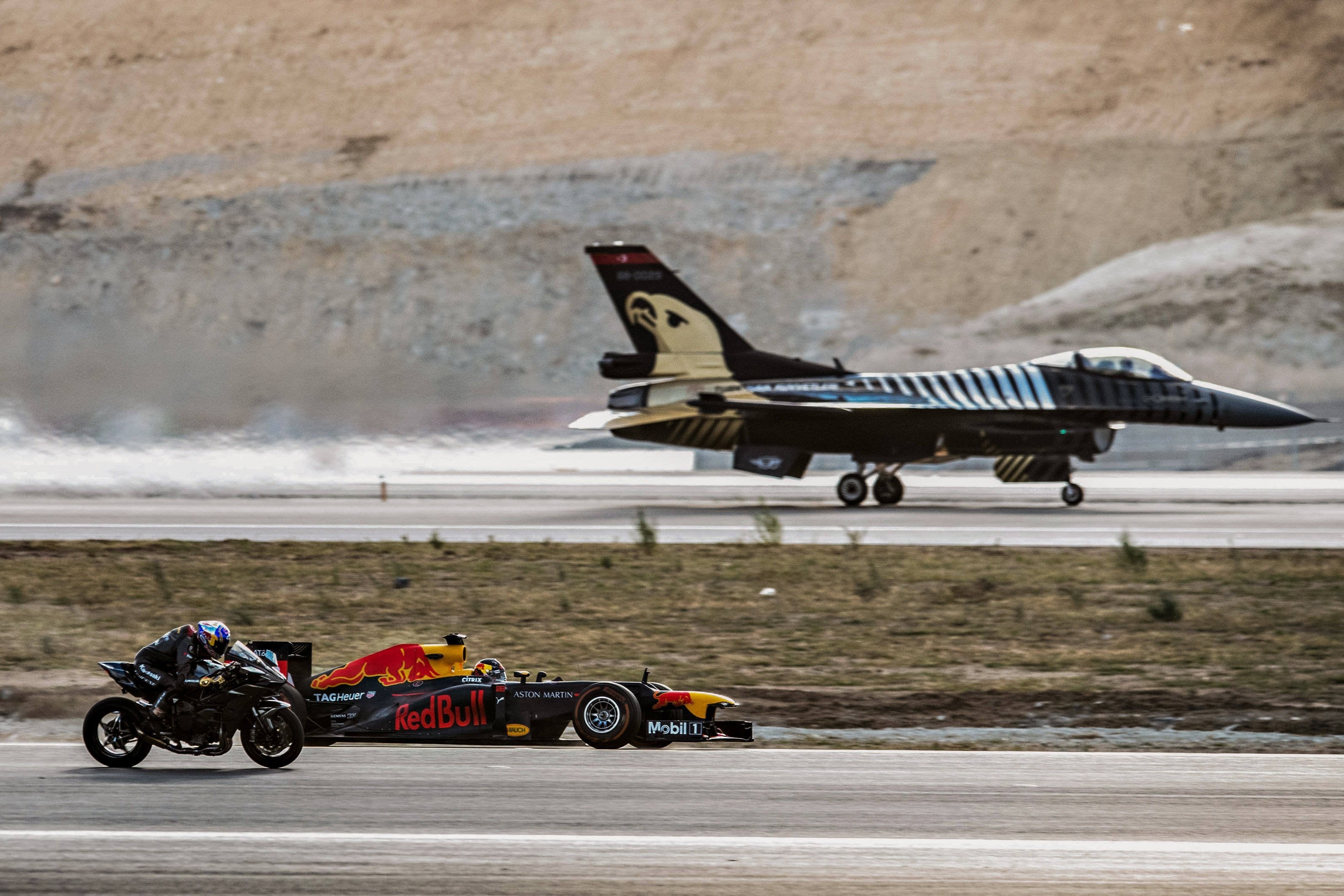 Red Bull F1 car, motorcycle, and F-16 jet on runway HD Wallpaper