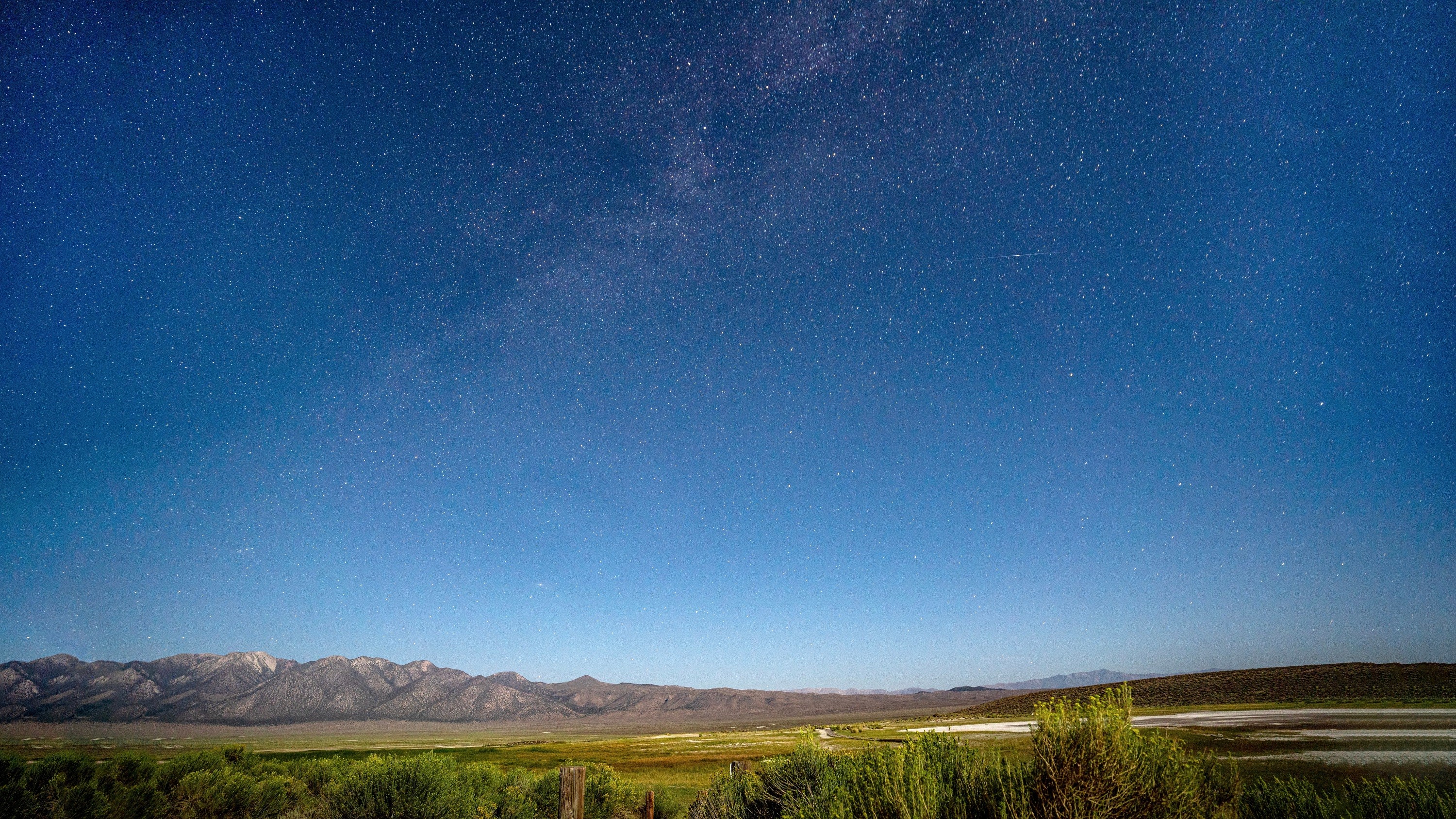 Starry night over mountains and fields HD Wallpaper