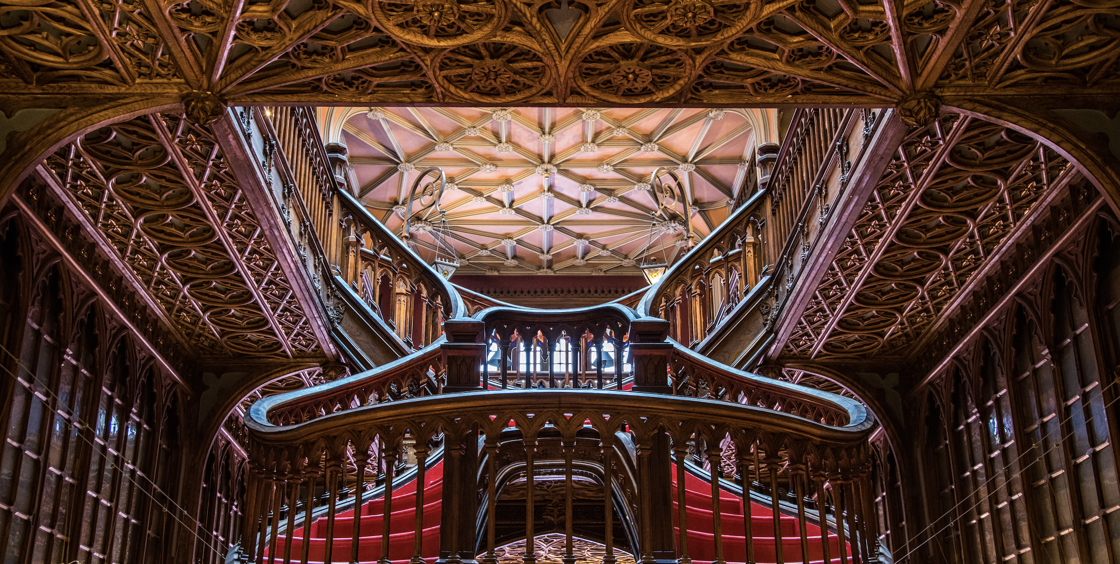 Ornate wooden staircase and ceiling in Livraria Lello bookstore, Porto, Portugal HD Wallpaper